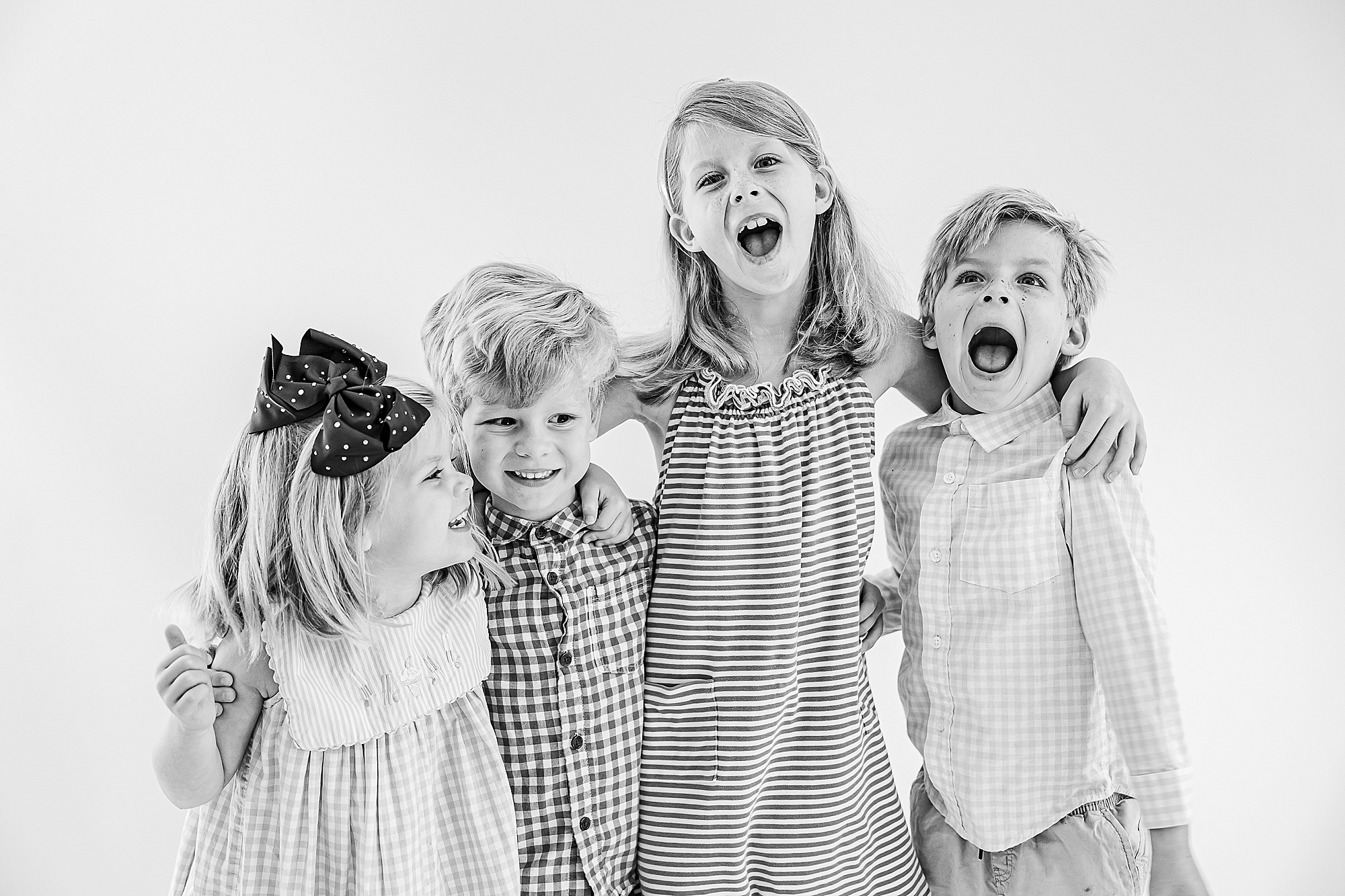 personality portraits for four siblings laughing in Charlotte studio