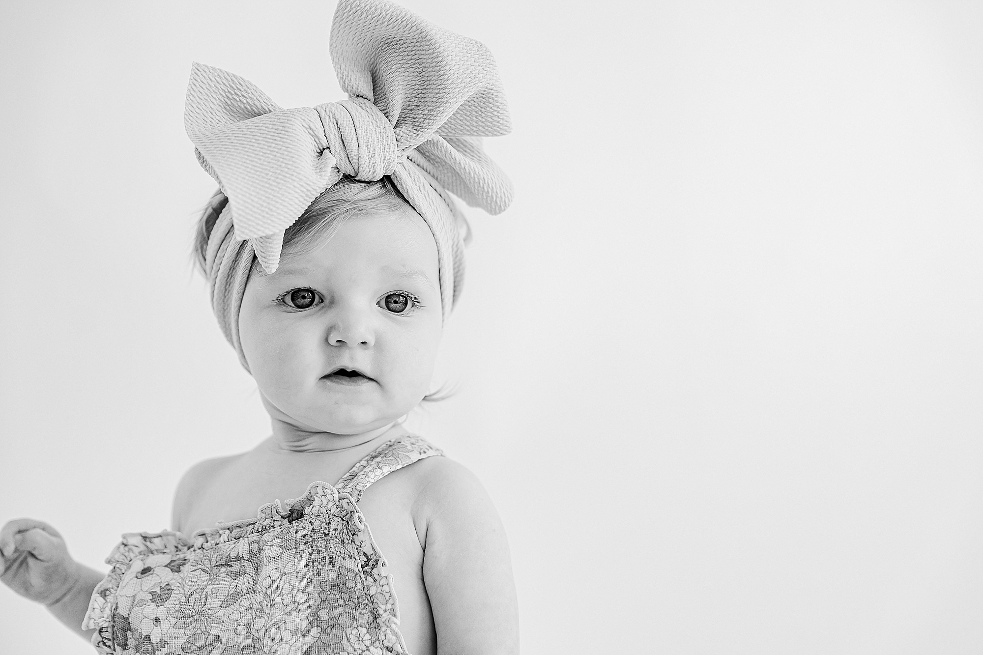 little girl in big headband smiles during Charlotte personality portraits