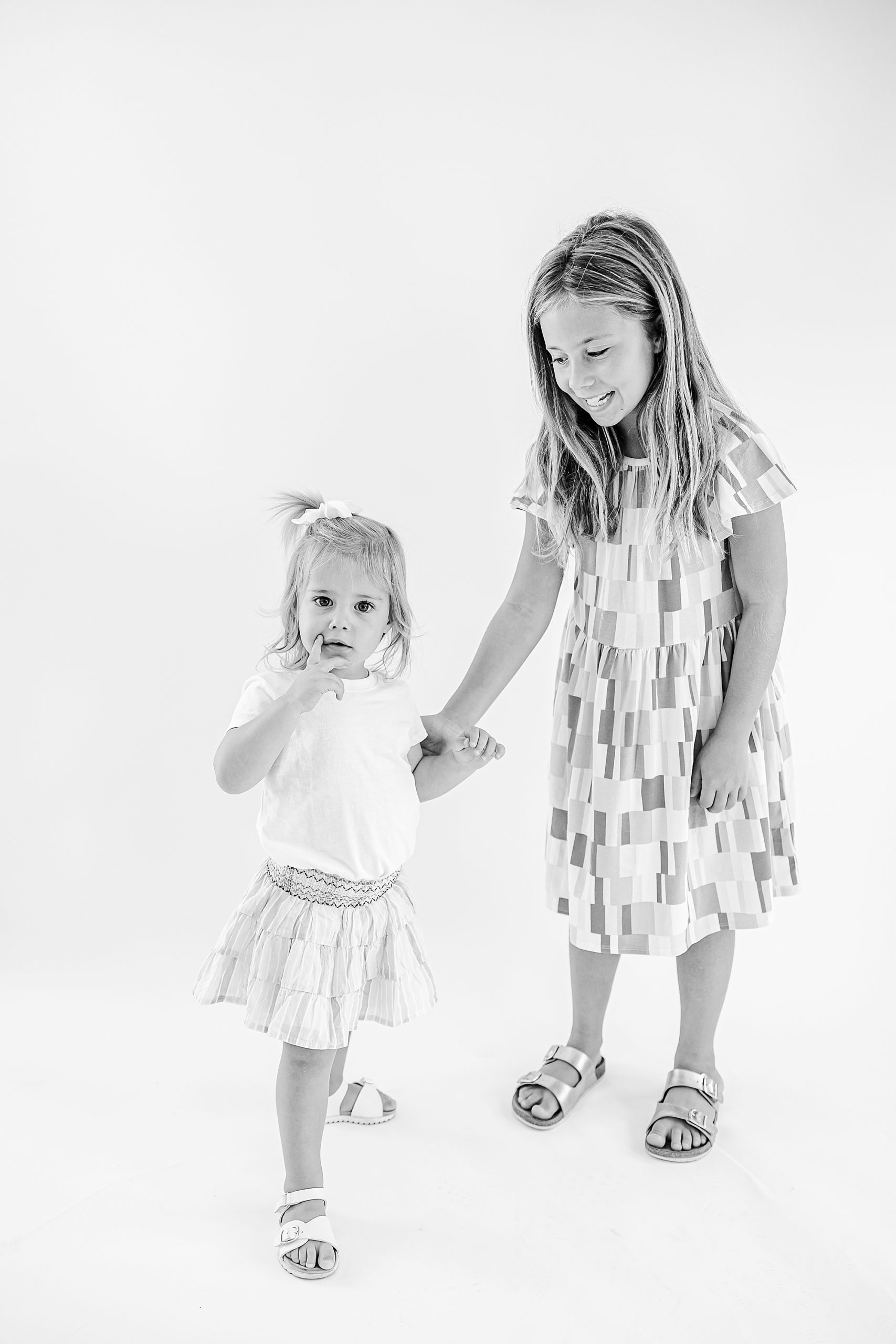 sisters hold hands during studio personality portraits