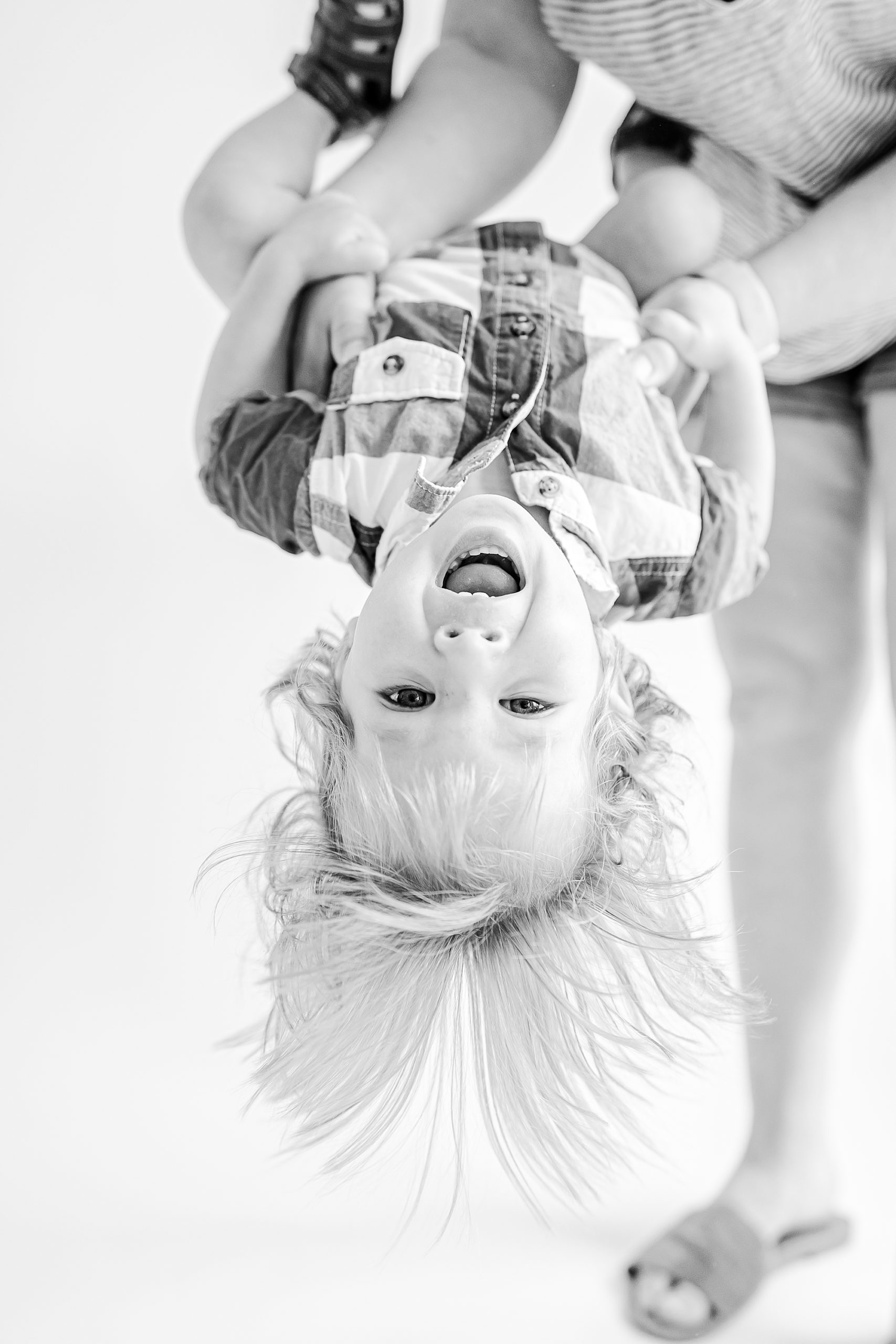 mom lifts son upside down during studio personality portraits