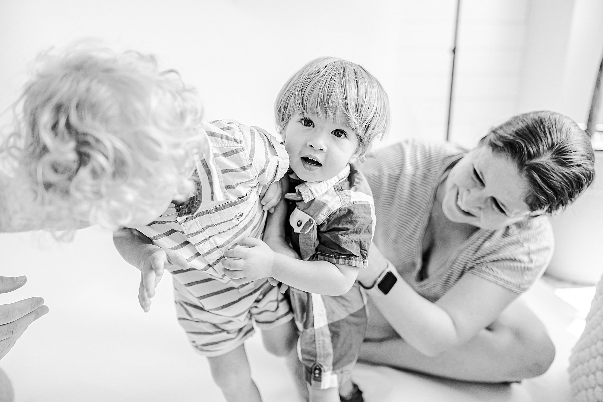 mom plays with two sons during studio portraits 