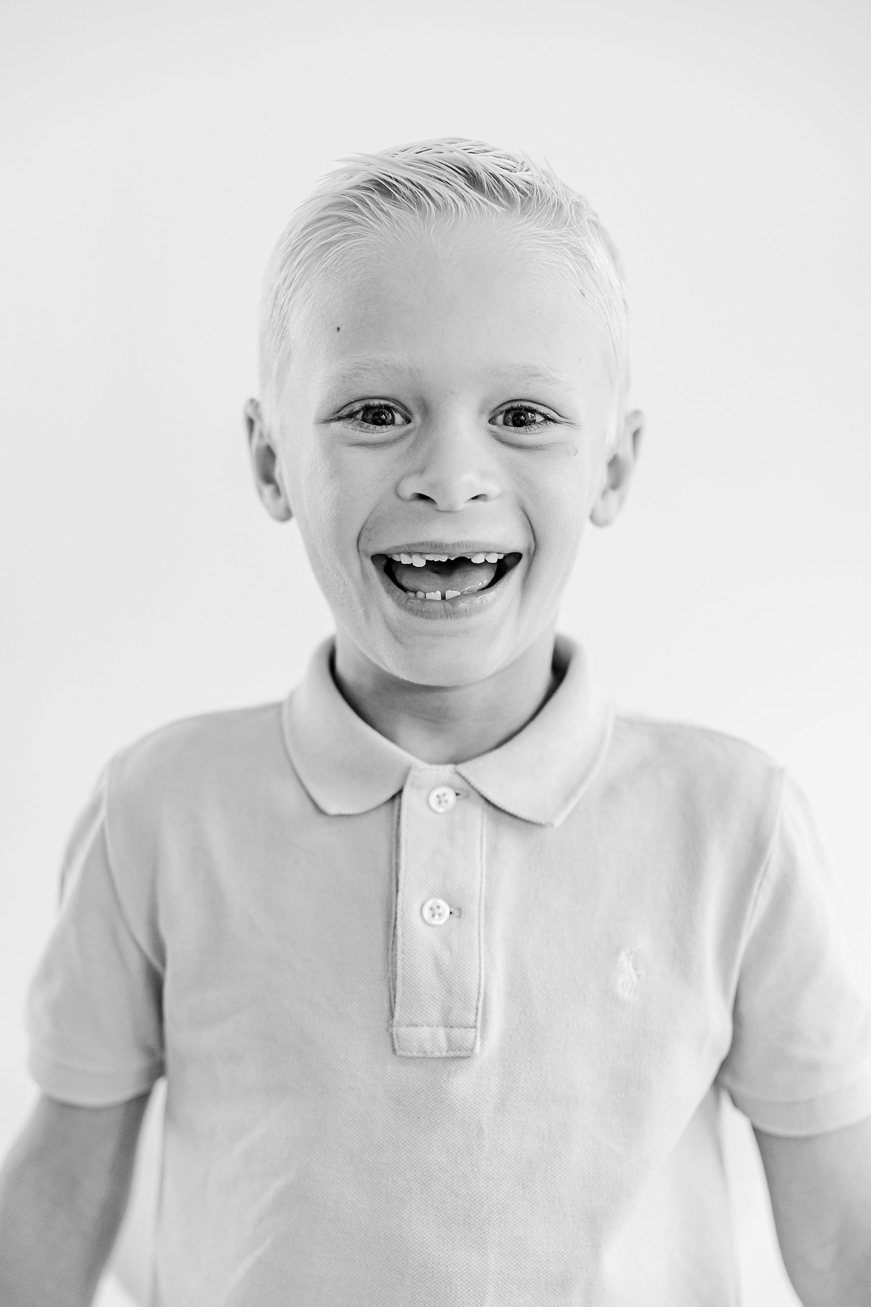 boy laughs missing front teeth in polo