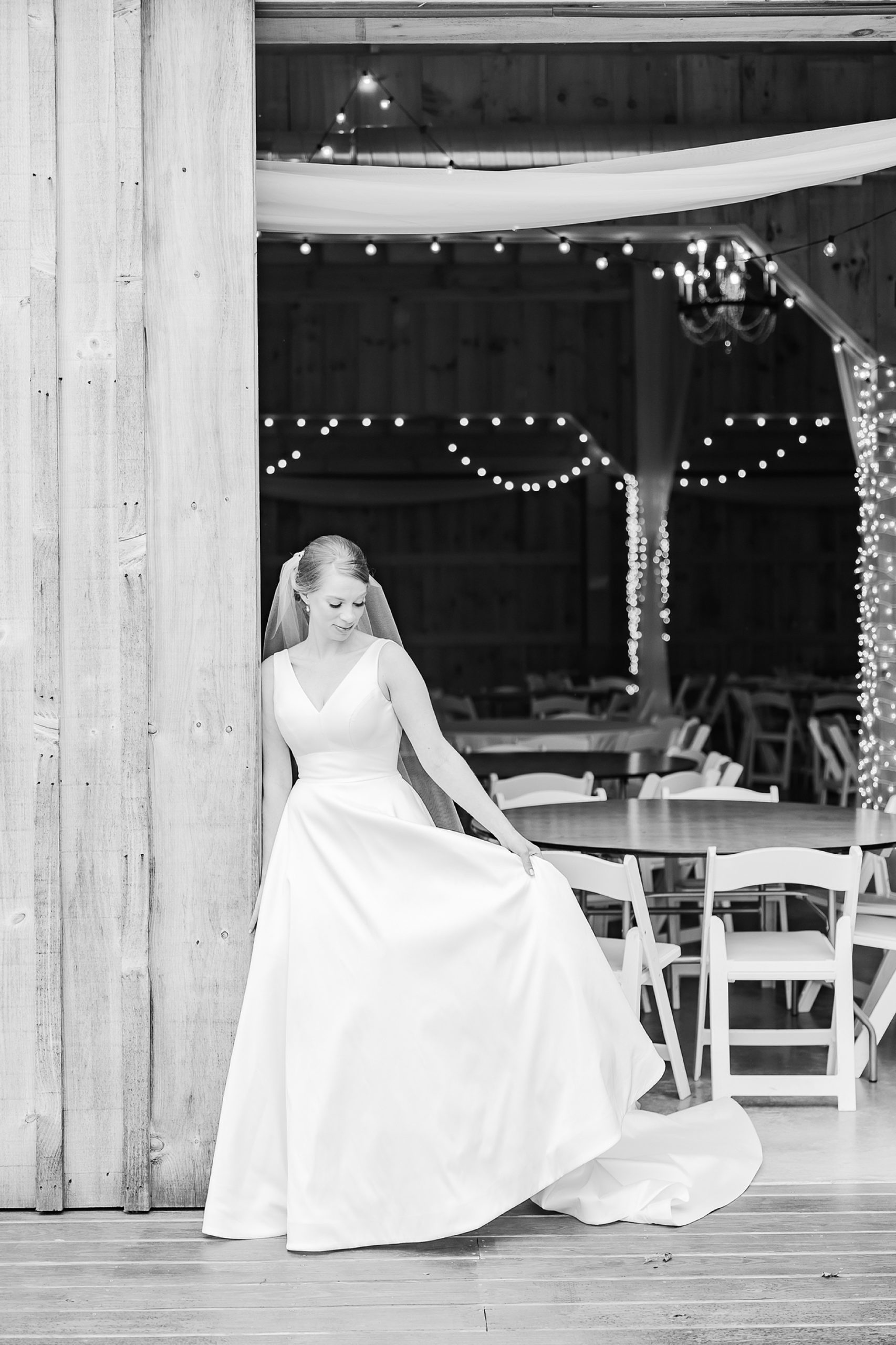 bride smiles down at wedding dress at Old Homeplace Vineyards