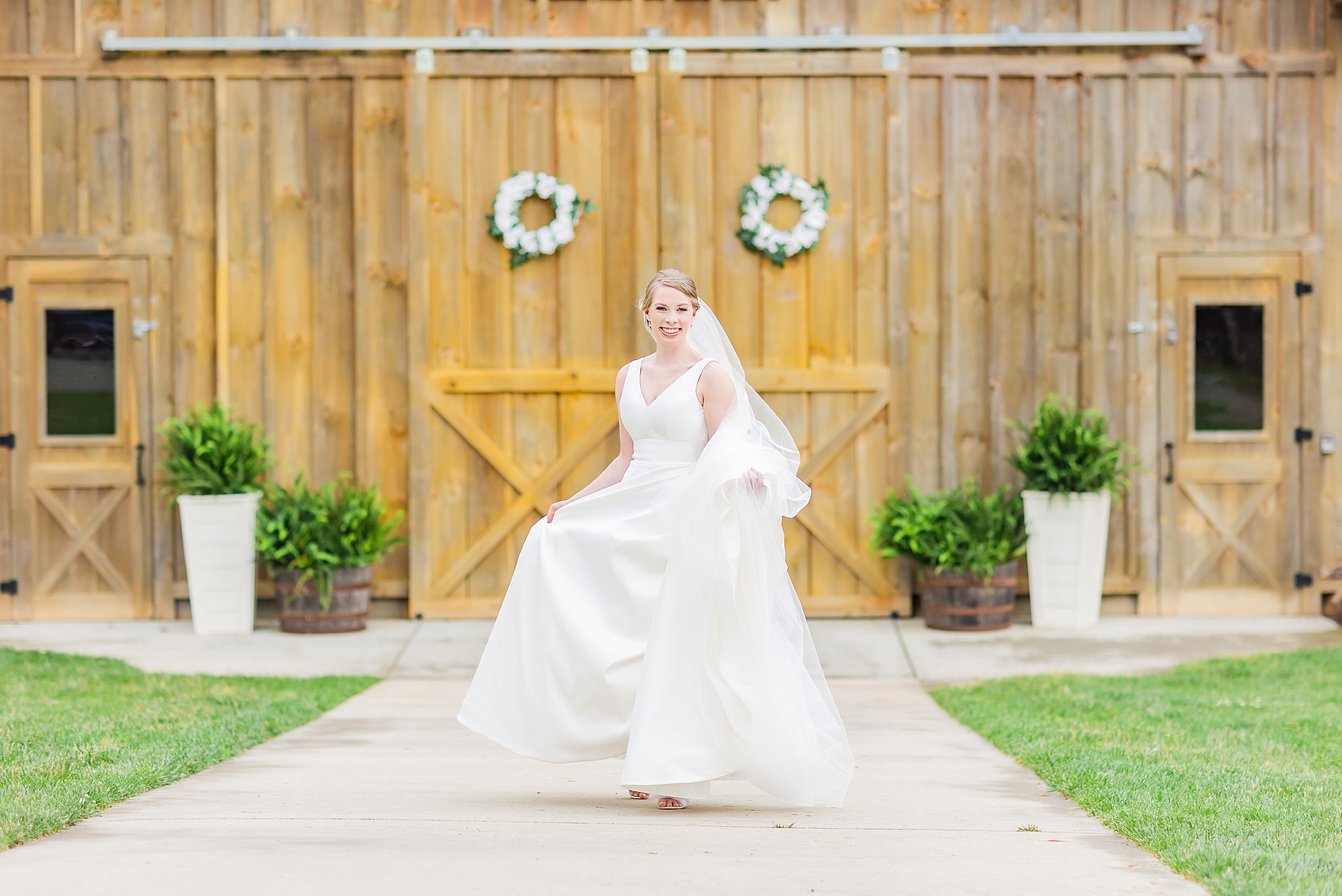 bride runs outside barn photographed by Charlotte wedding photographer