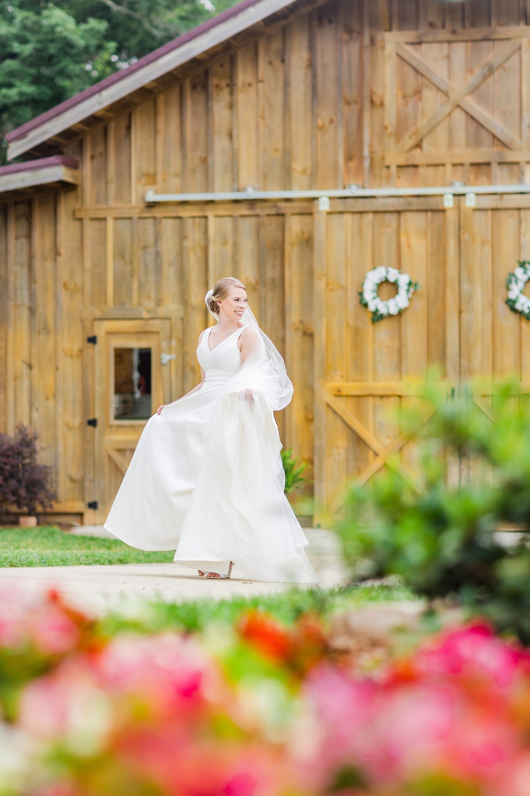 bride walks outside wooden barn at Old Homeplace Vineyard