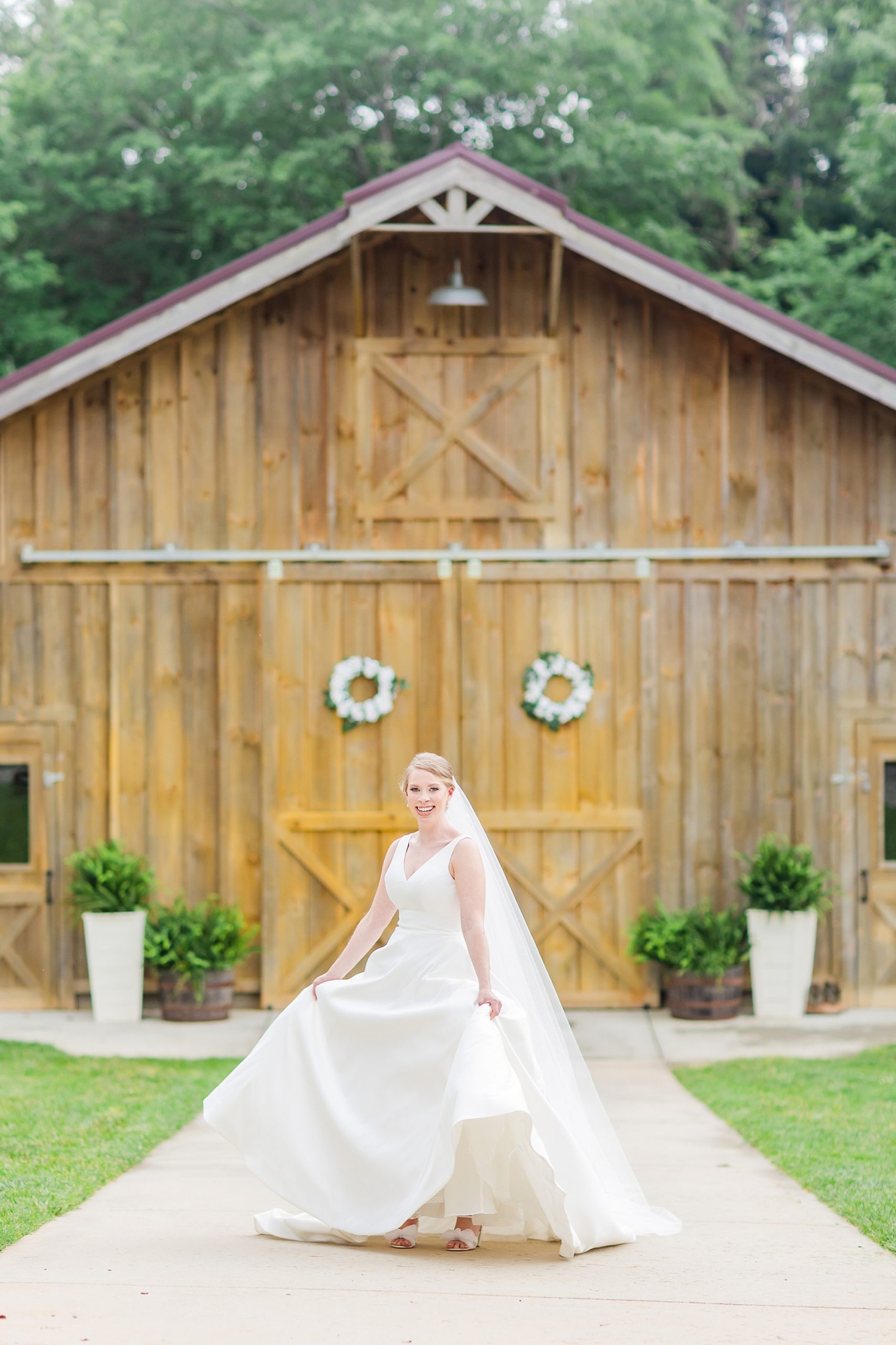 bride-to-be walks in wedding dress outside wooden barn at Old Homeplace Vineyard