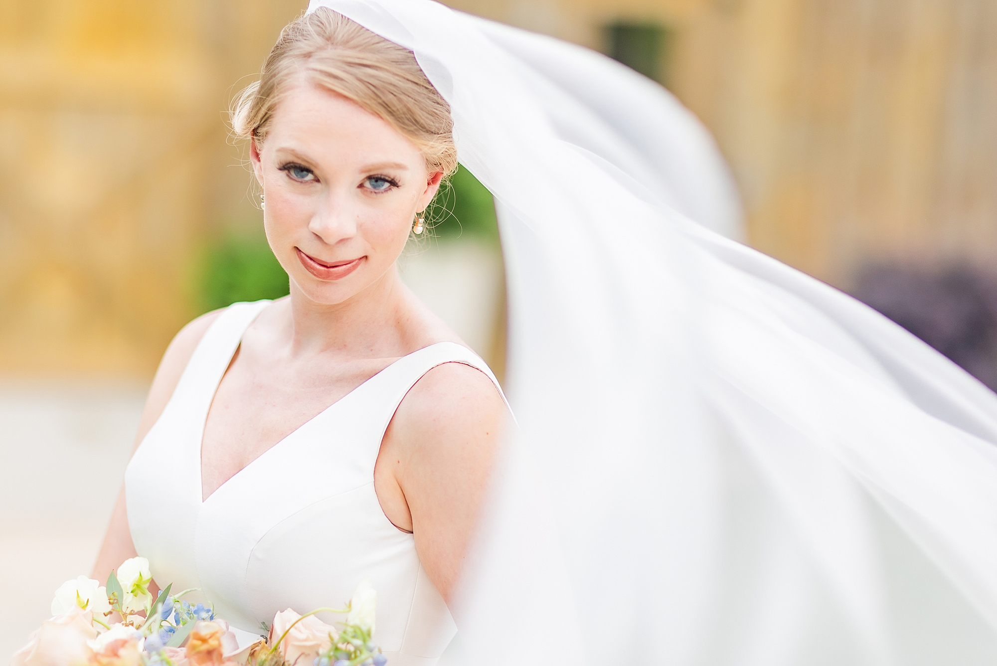 bride smirks during portraits outside barn 
