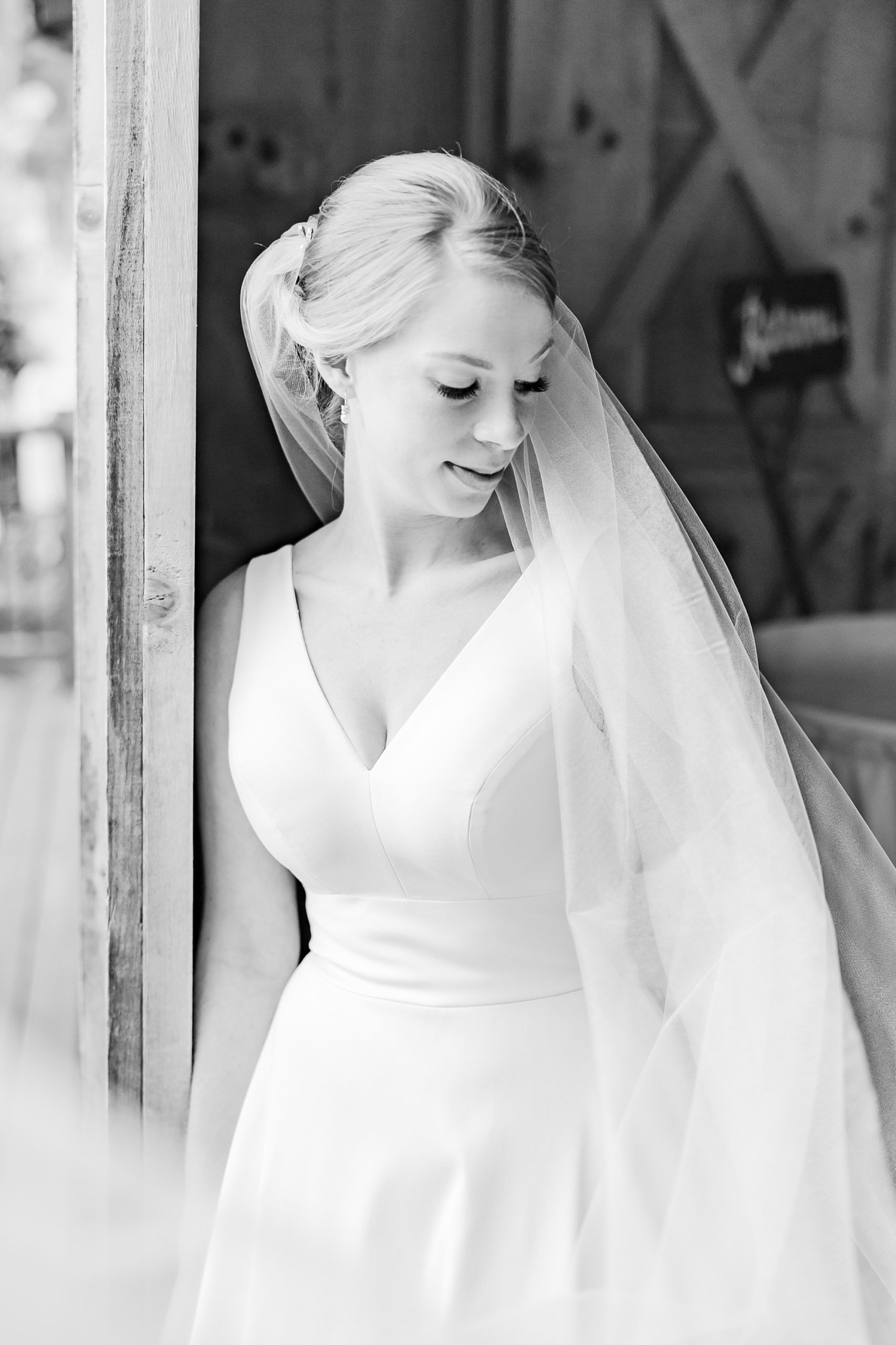 black and white portrait of bride looking over shoulder with veil around her