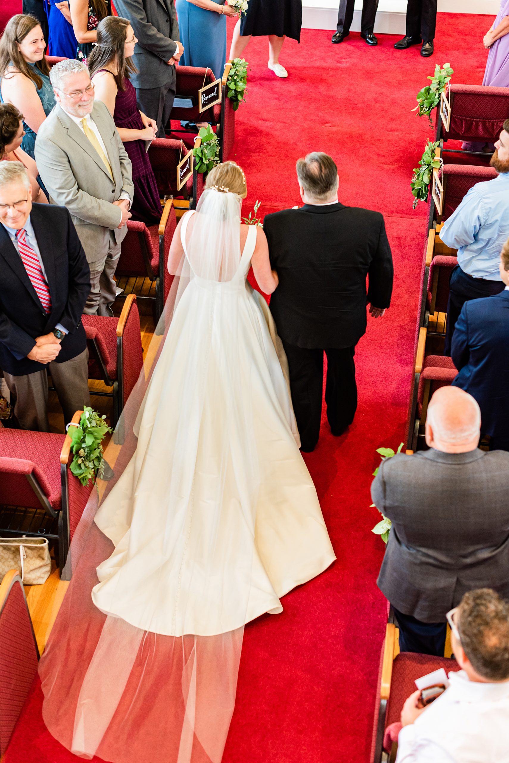 bride walks into wedding ceremony with father at church