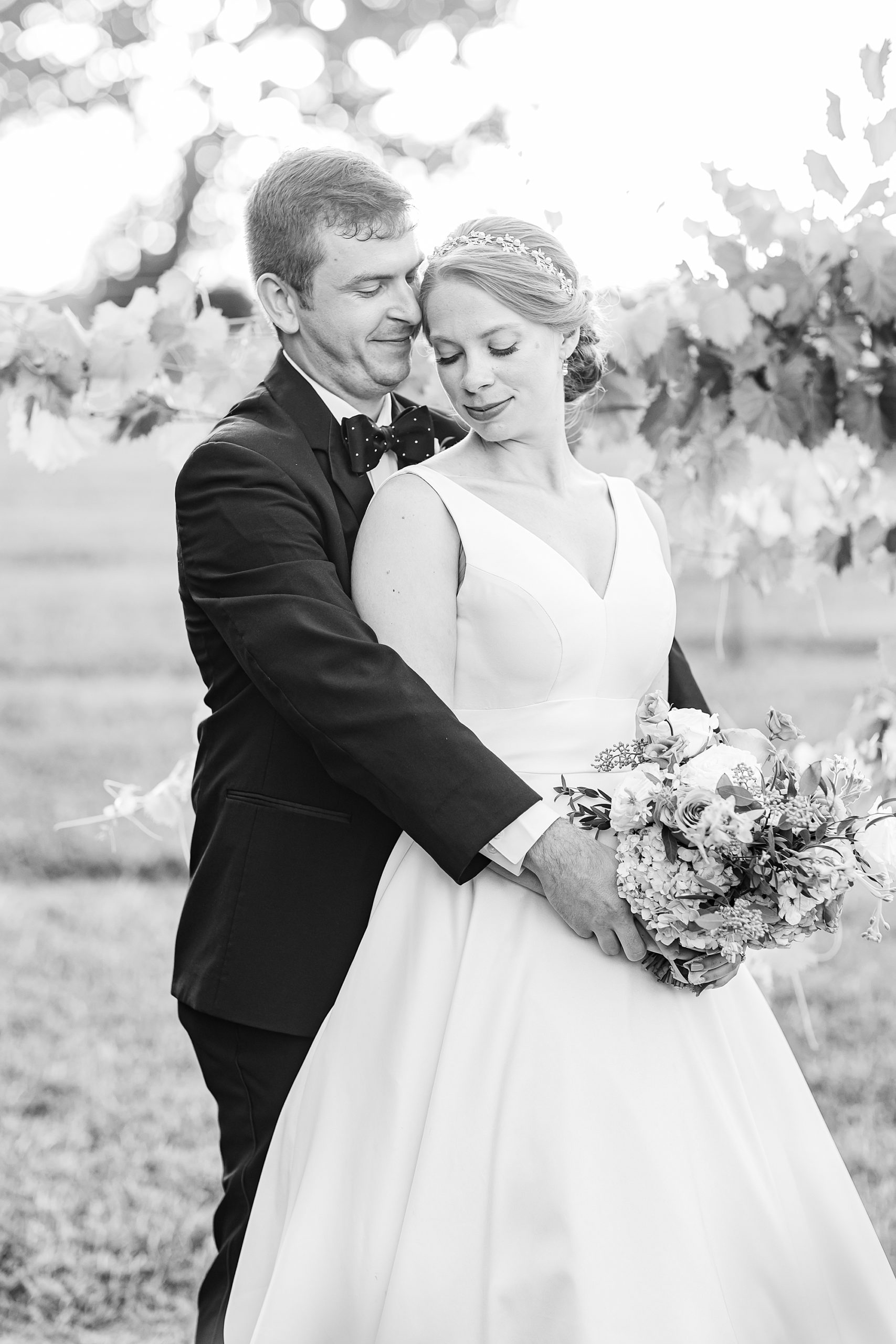 groom nuzzles bride's cheek during NC portraits at Old Homeplace Vineyard