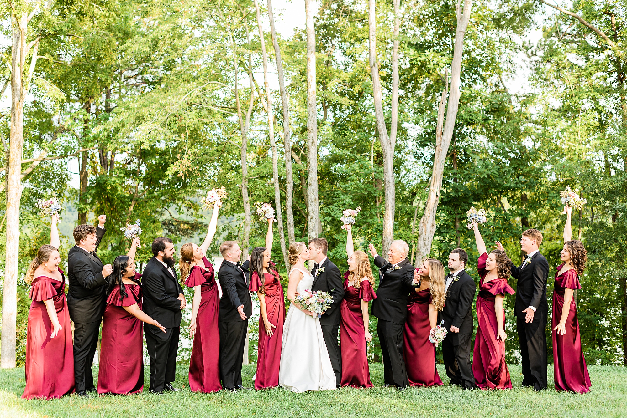 newlyweds kiss while bridal party cheers at Old Homeplace Vineyard