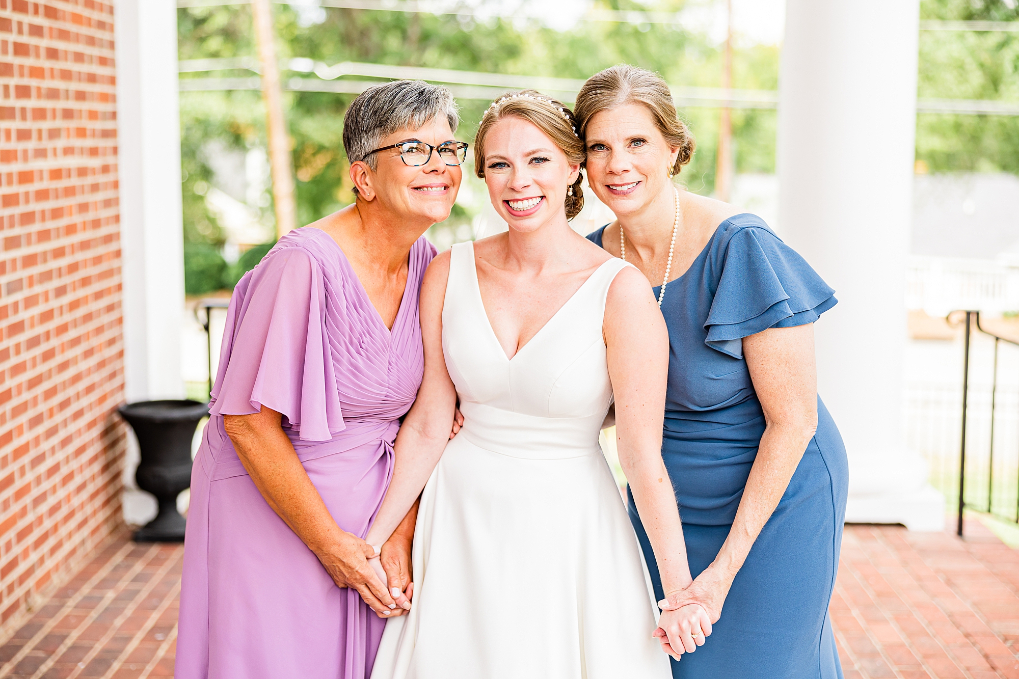 mother and grandmother stand with bride on church porch