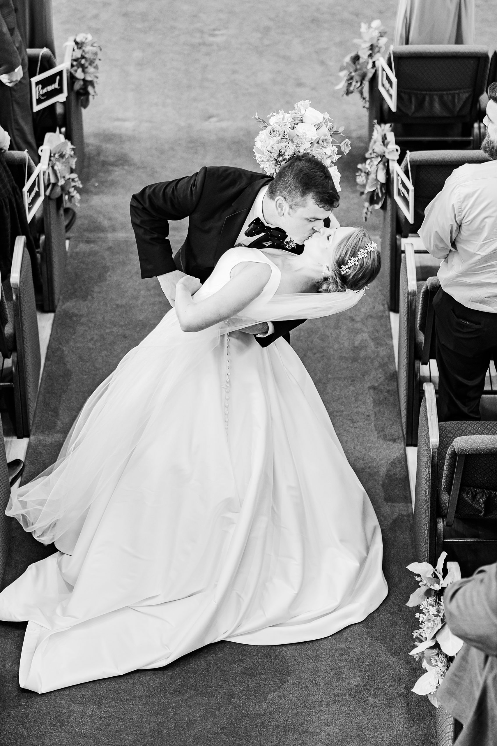 groom dips bride in aisle during traditional wedding ceremony at College Park Baptist Church