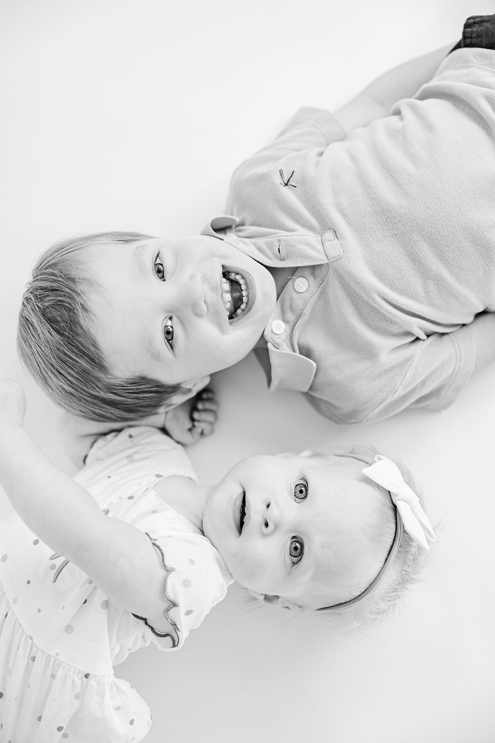 brother and sister lay on floor together during studio personality portraits