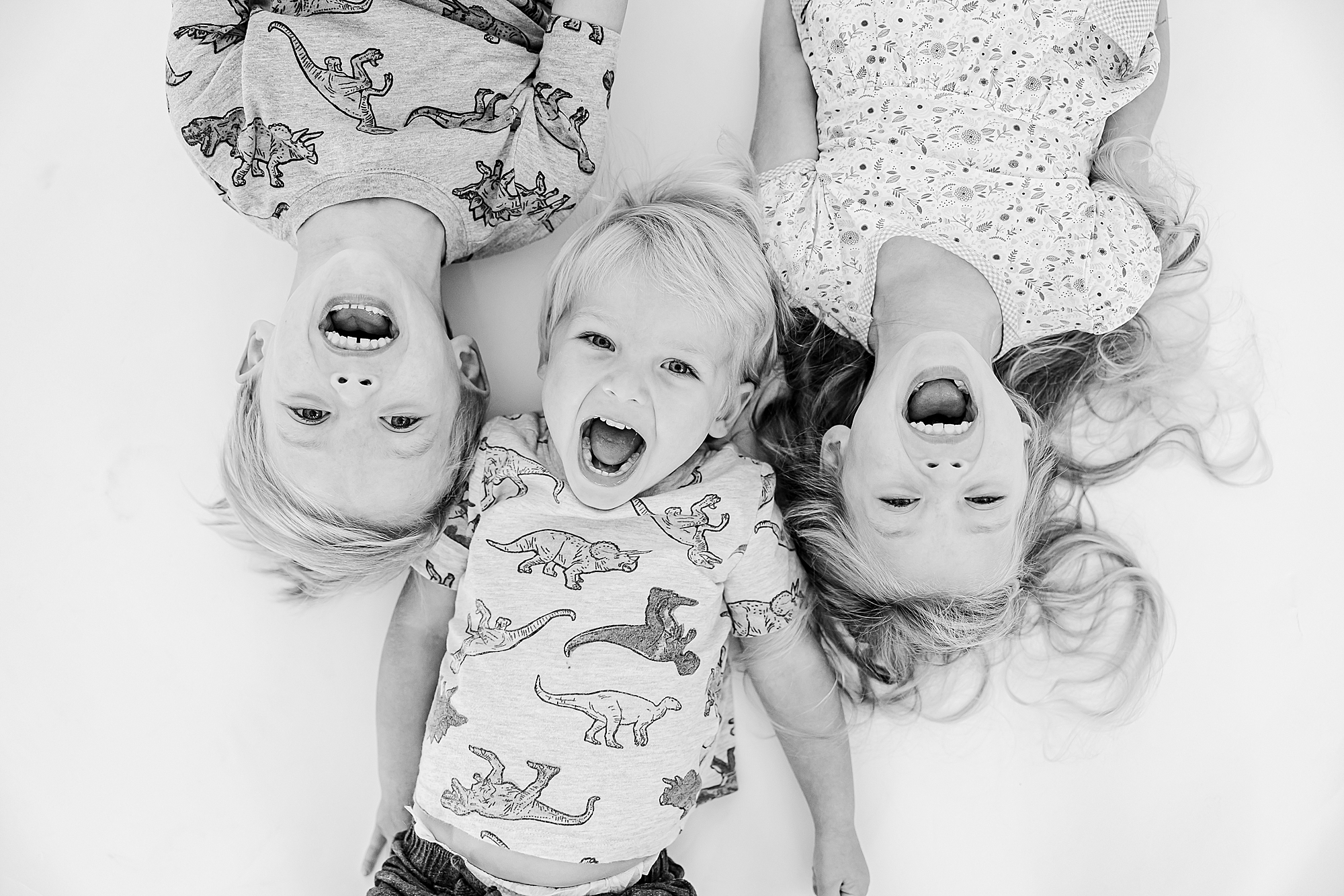 kids laugh out loud laying on floor during studio personality portraits