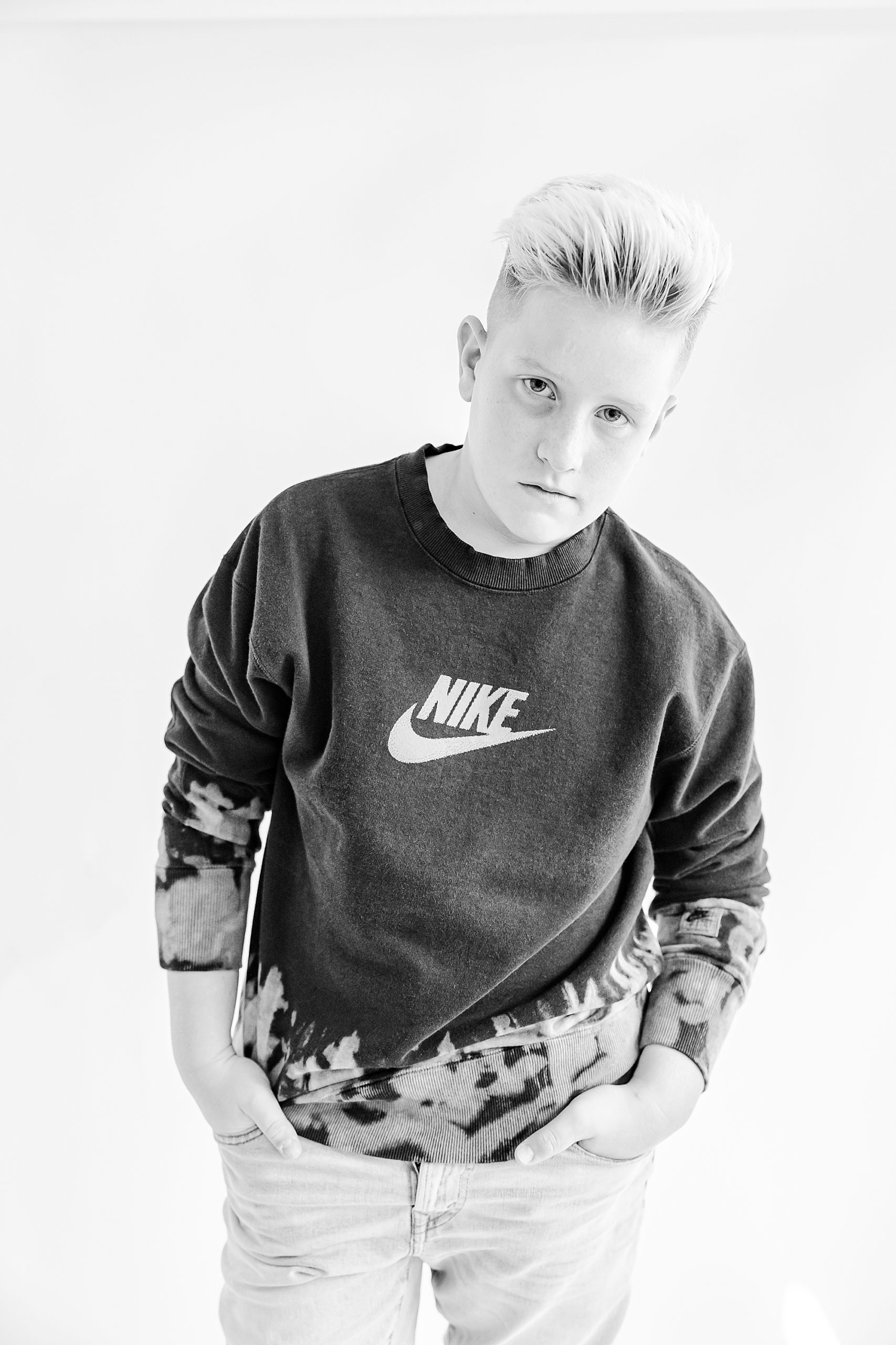 teenager stands with hands in pocket wearing NIKE shirt during studio personality portraits