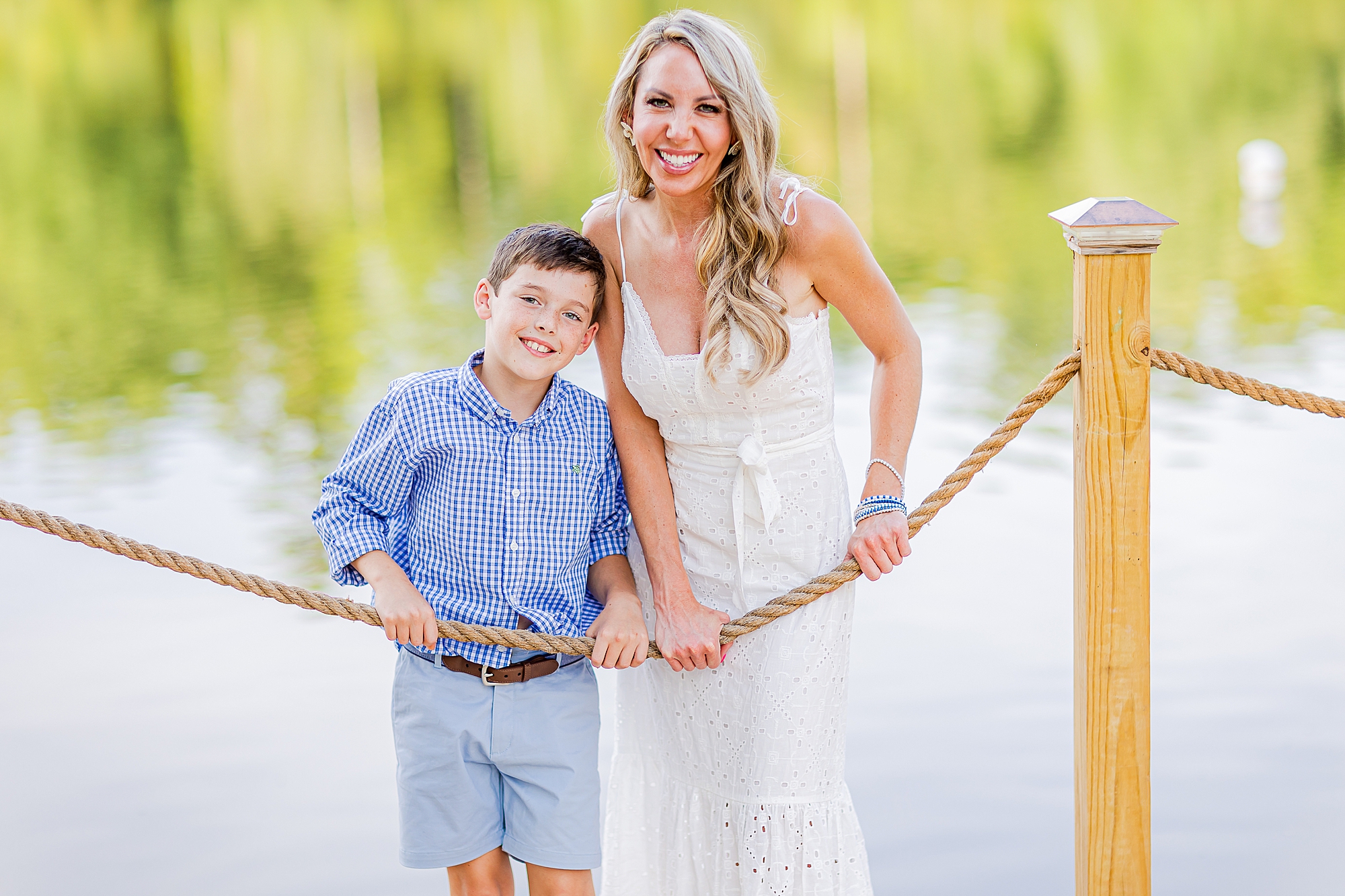 mom stands with son against rope near lake Norman