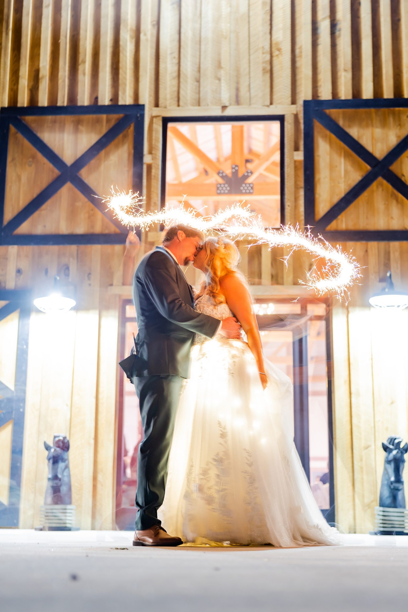 bride and groom kiss with sparkler around them