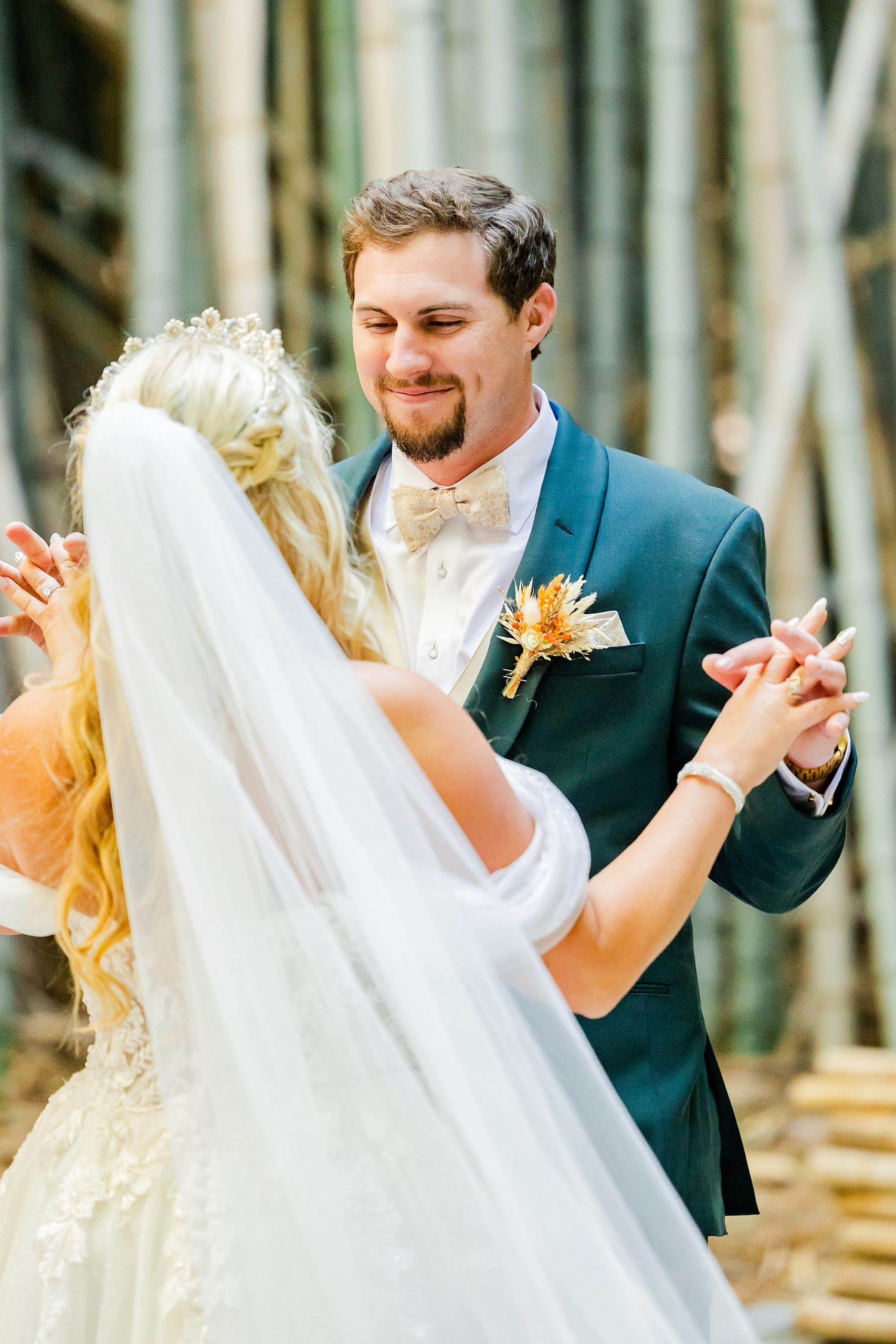 bride and groom hold hands during first look 