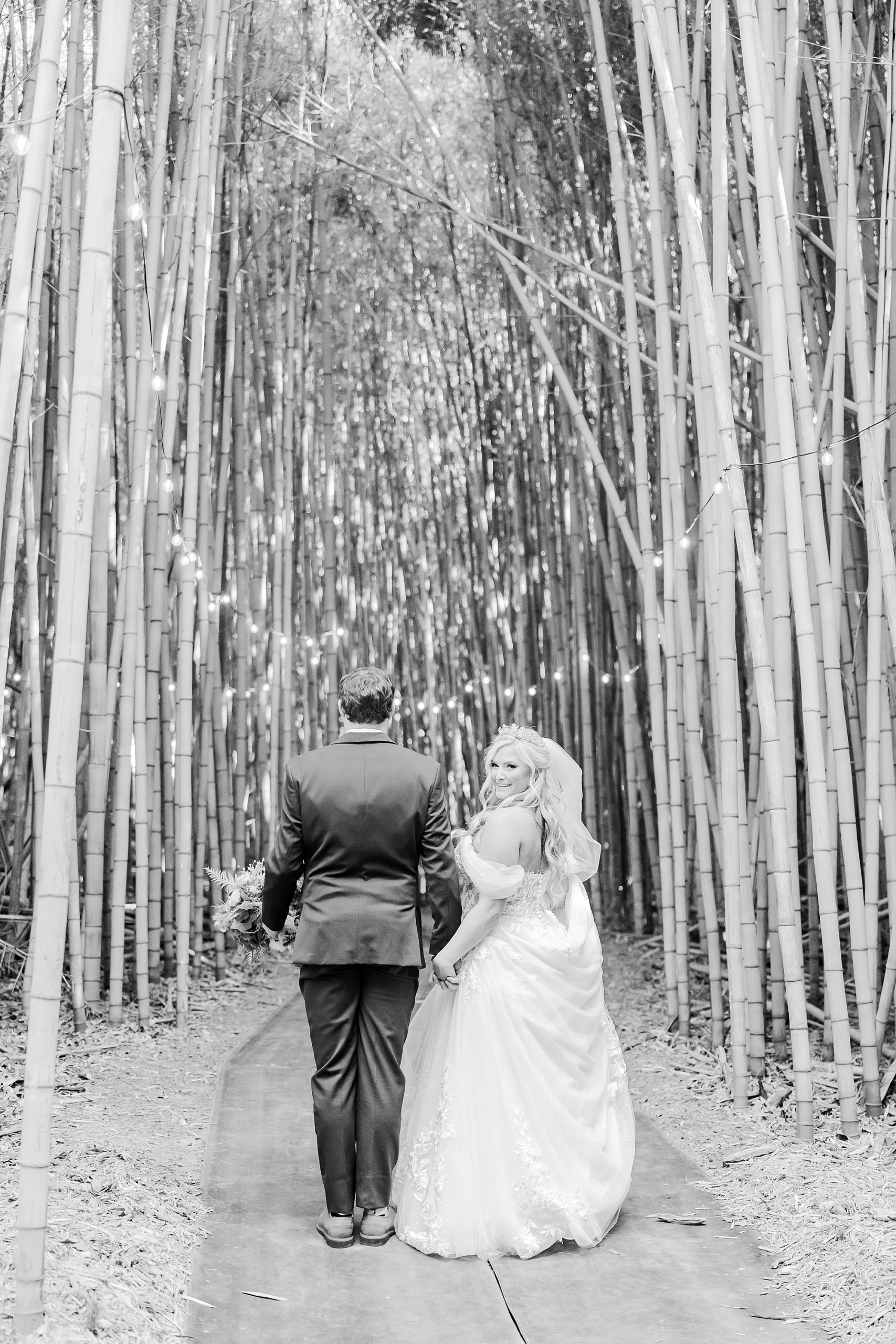 newlyweds walk through bamboo forest at Camelot Meadows wedding