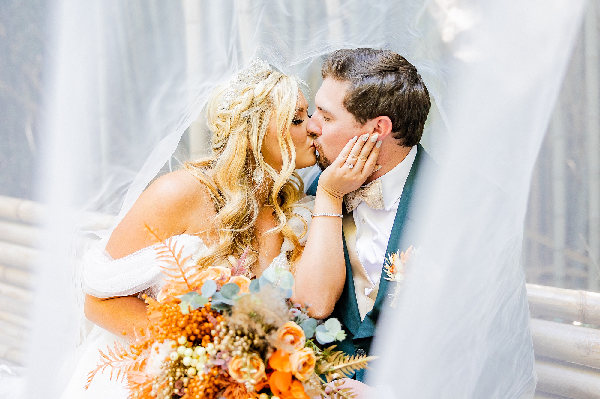 bride leans for kiss with groom at Camelot Meadows