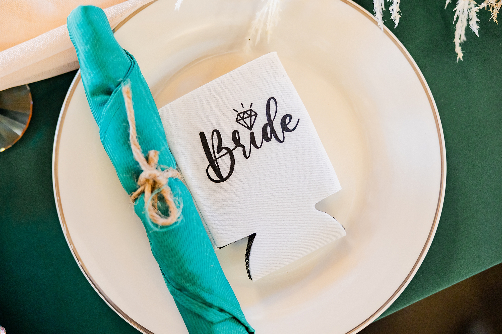 place setting for bride with teal napkins and bride koozie