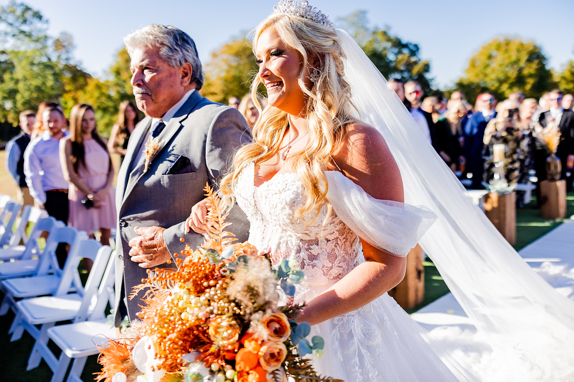 bride walks down aisle with dad for fall wedding ceremony at Camelot Meadows