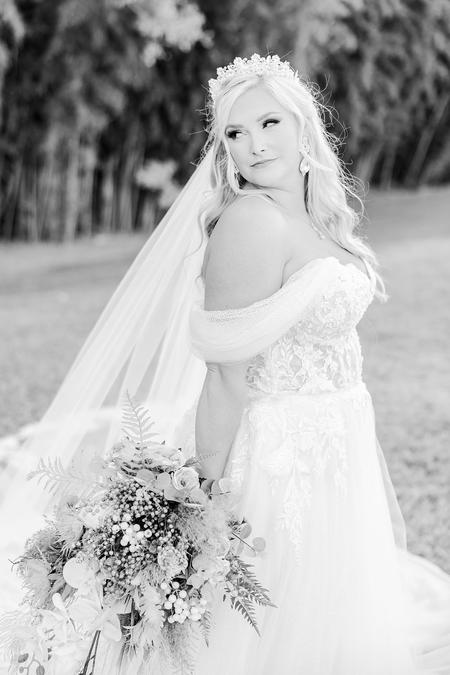 bride looks over shoulder holding bouquet behind her