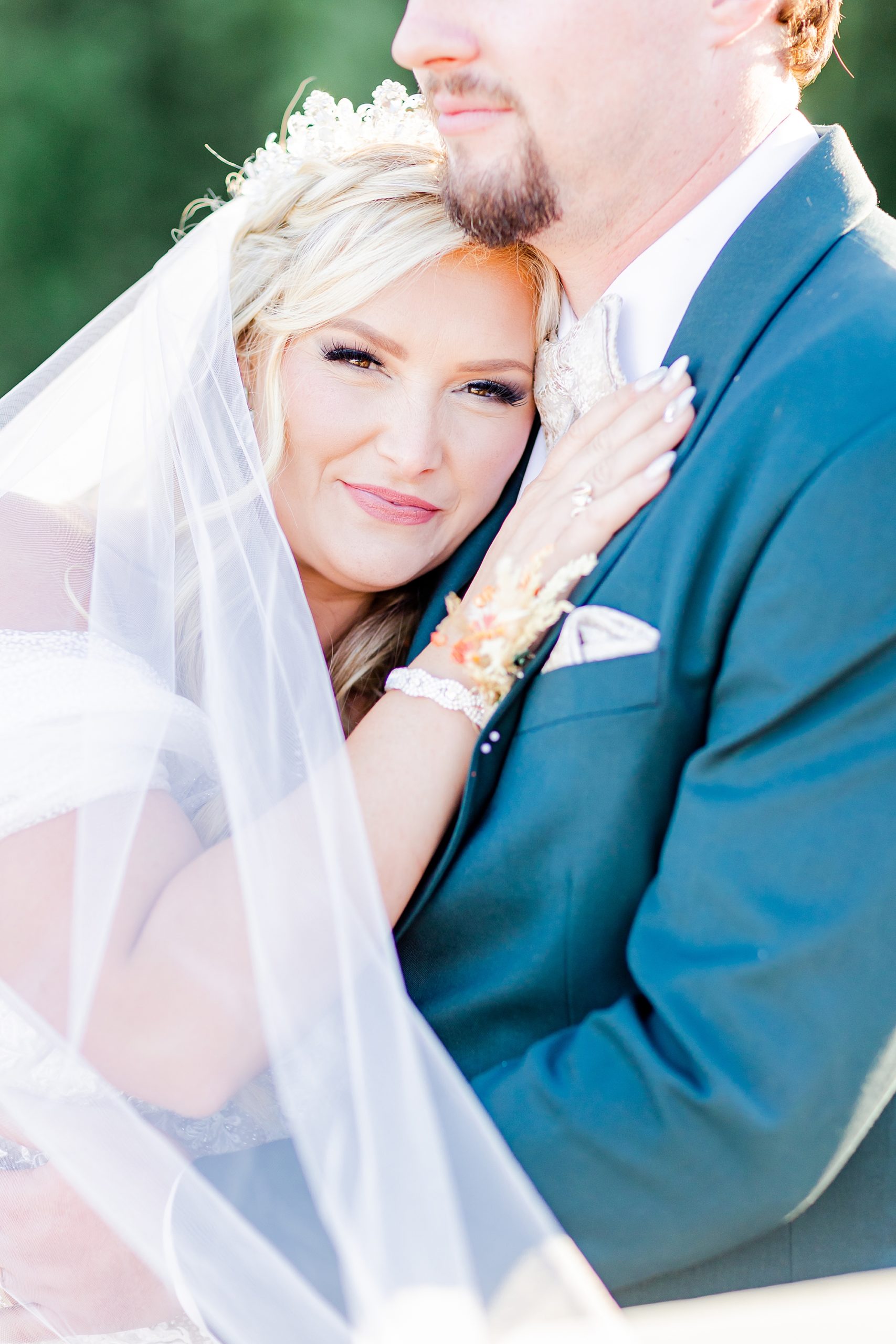 bride lays head on groom's chest during fall wedding at Camelot Meadows