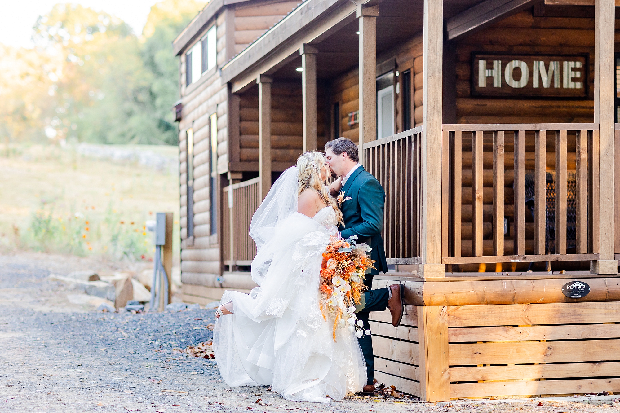 bride and groom hug by wood cabin at Camelot Meadows