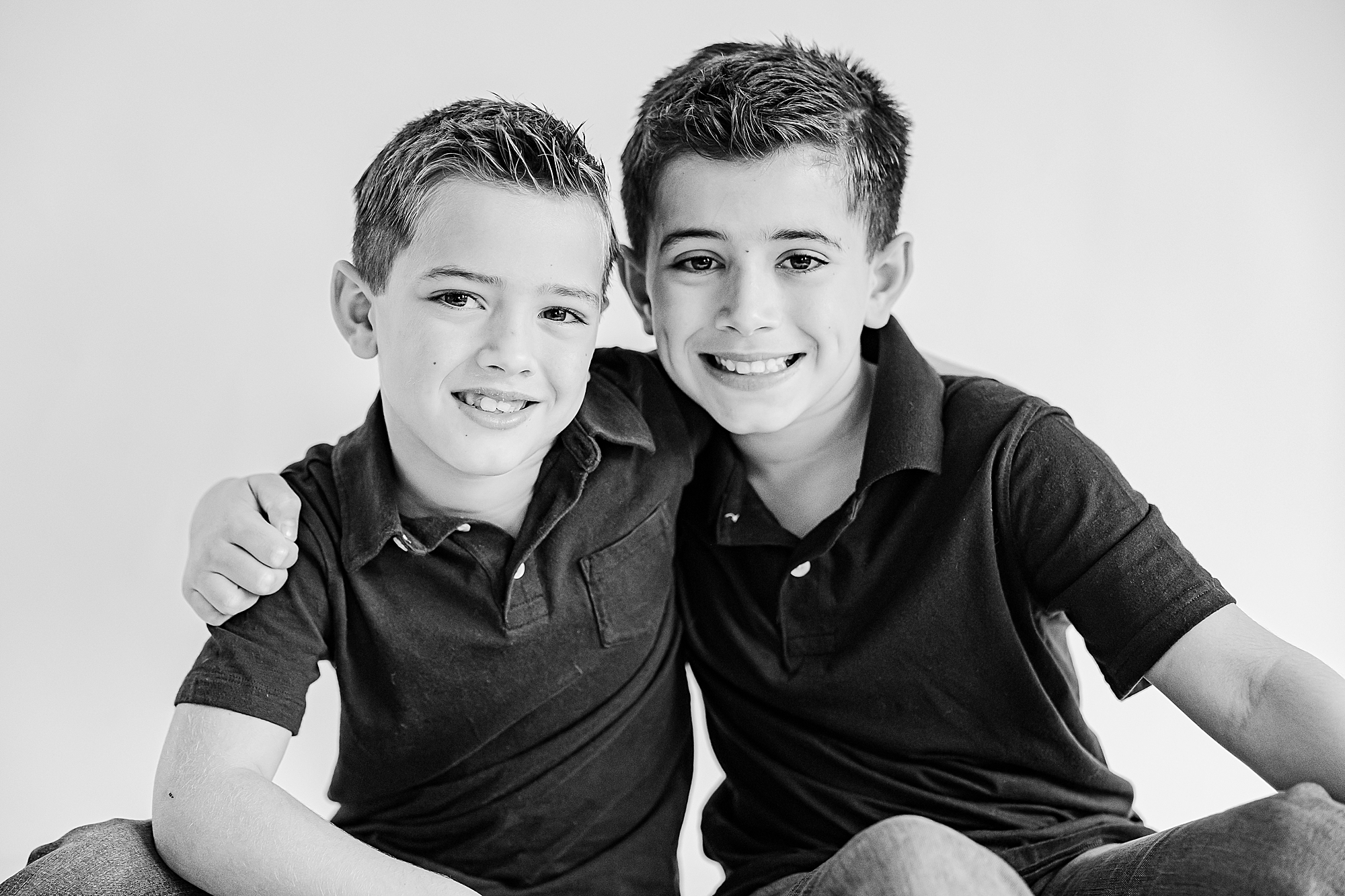 brothers in dark polos hug during Charlotte Personality Portraits 