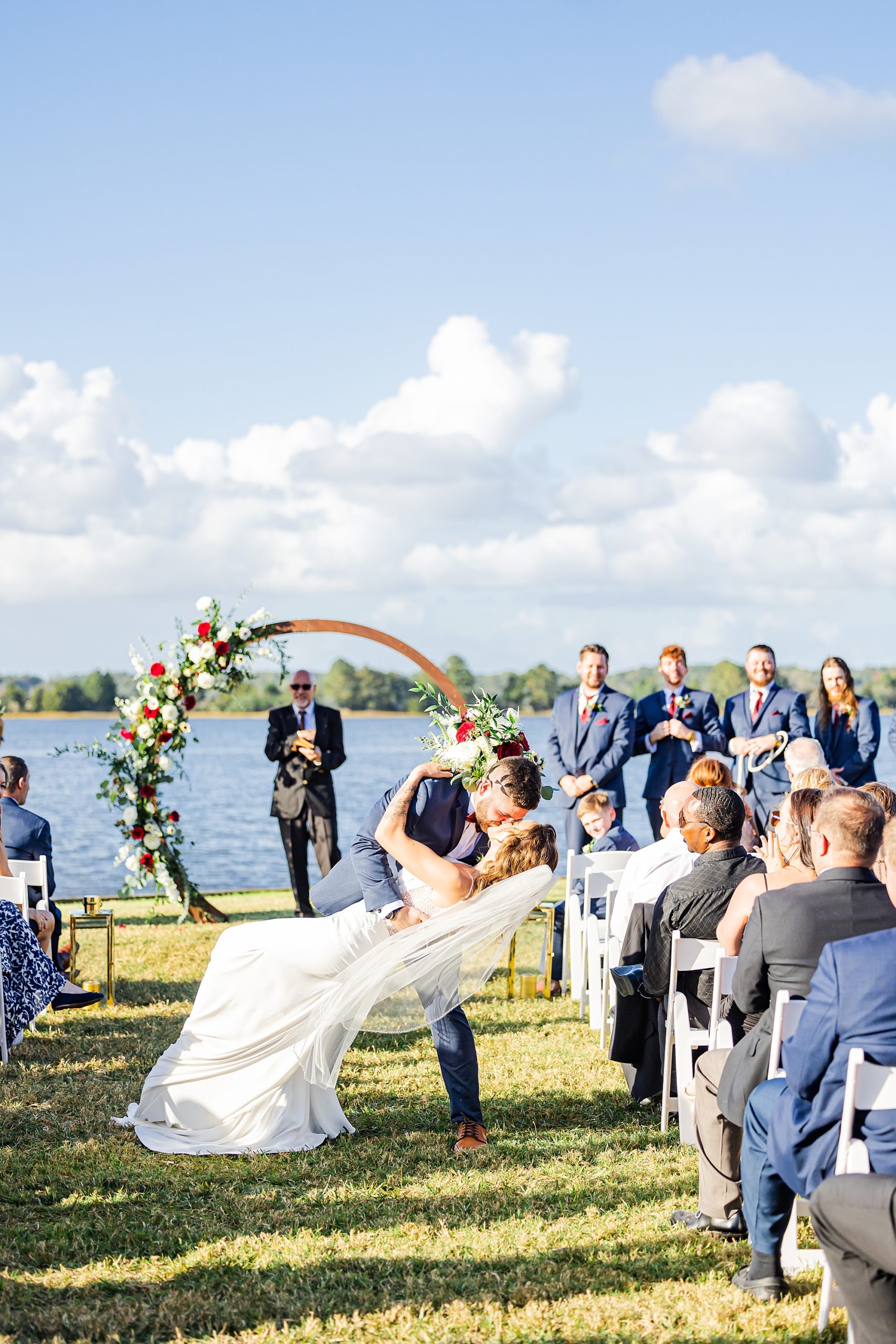 groom dips bride kissing her in aisle after ceremony 