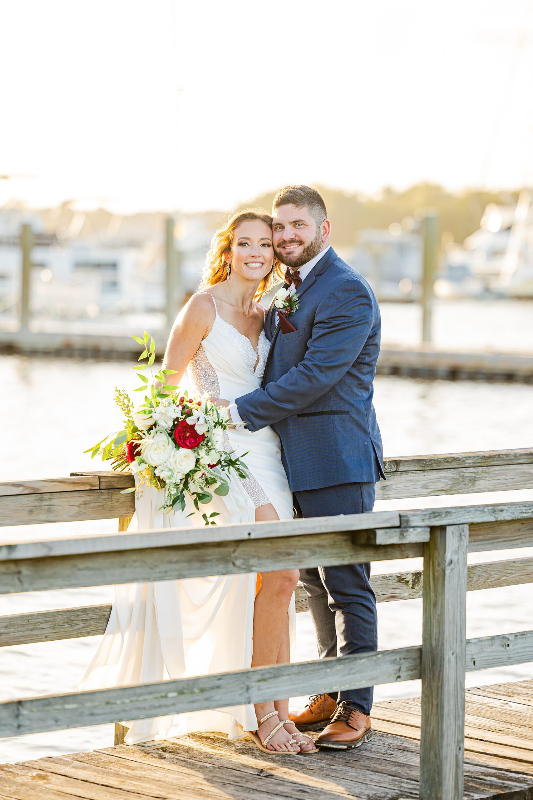 newlyweds pose on wooden pier during John's Island wedding portraits 