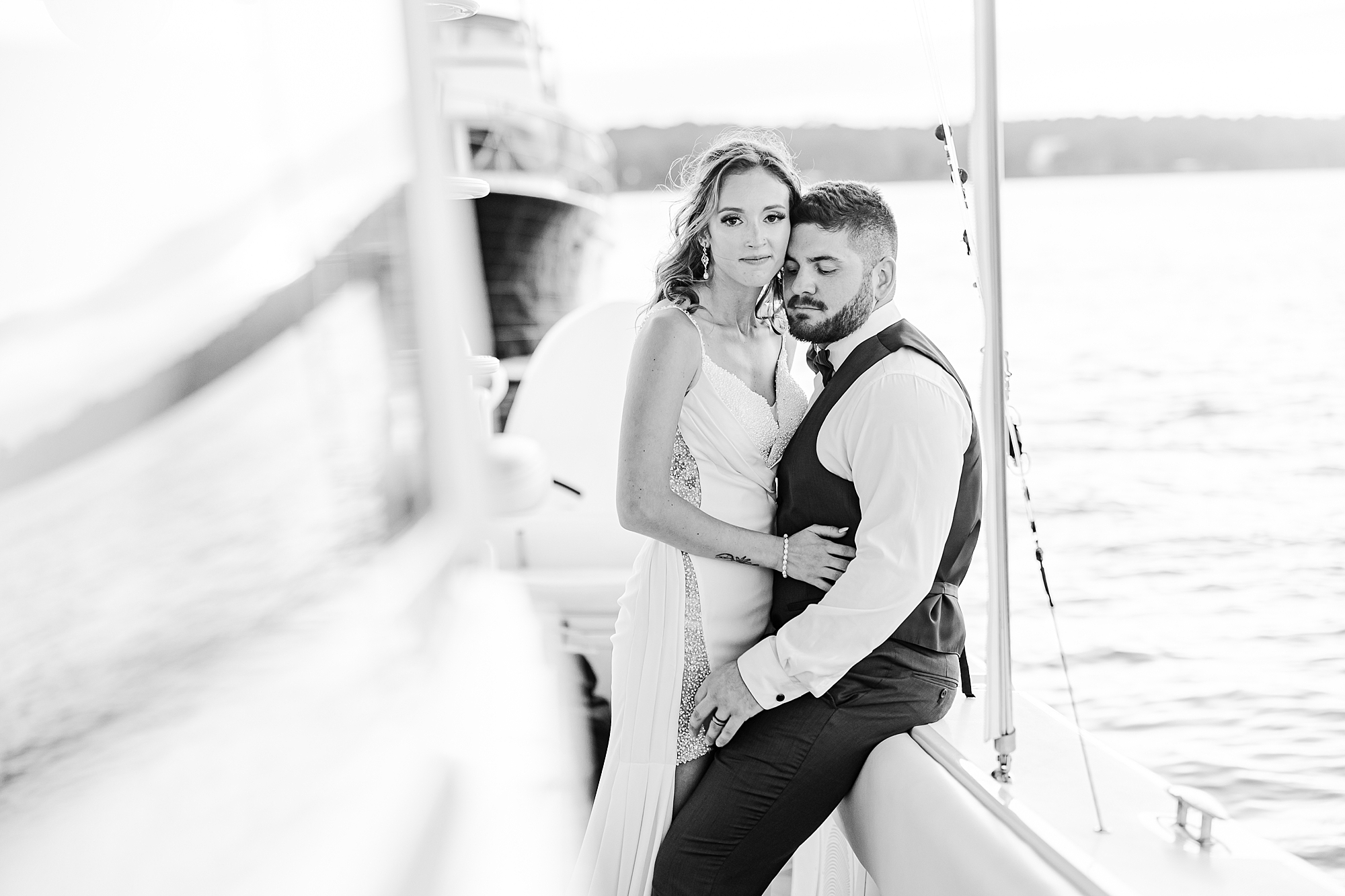 bride and groom sit on side of boat during portraits