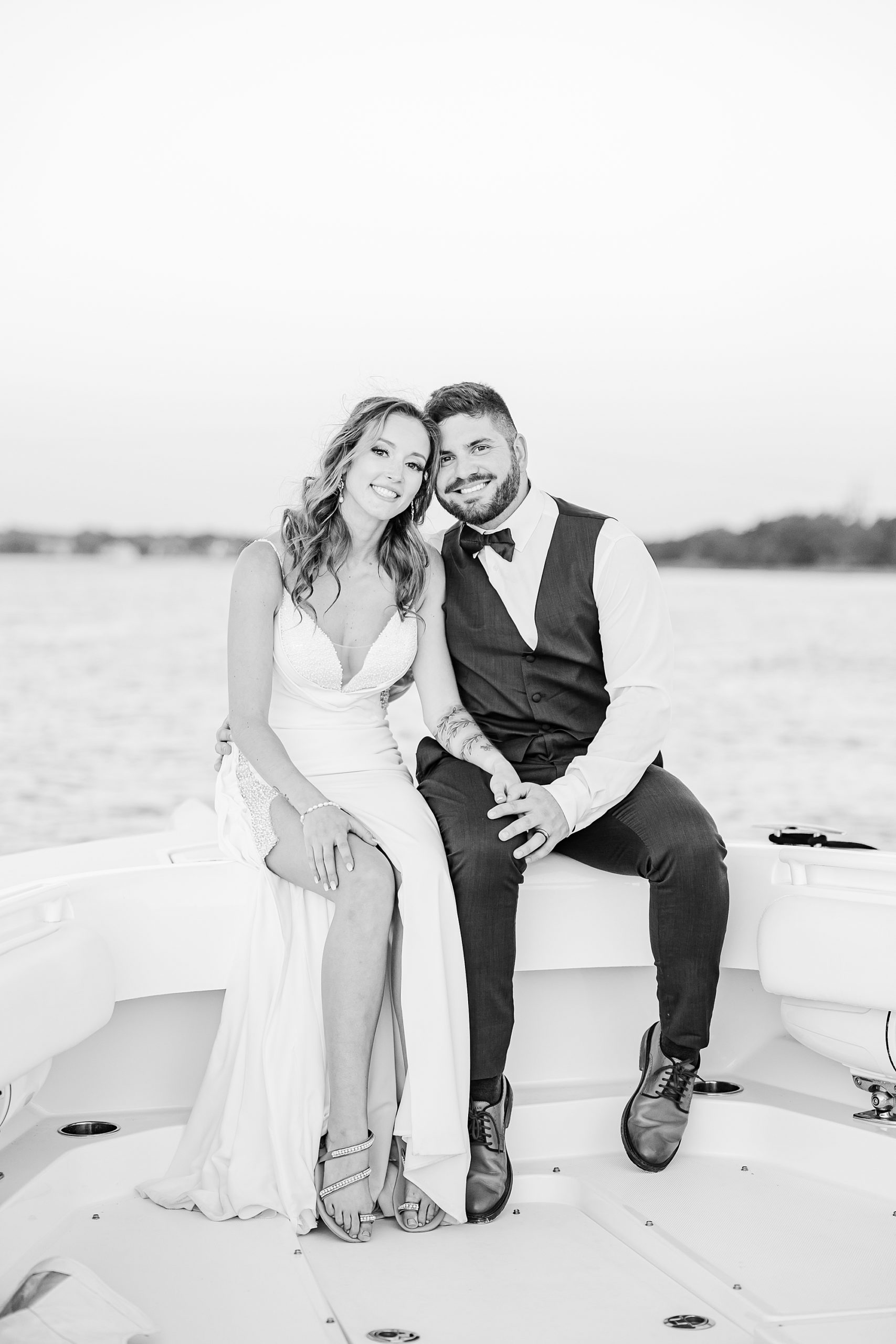newlyweds sit on front of boat together 