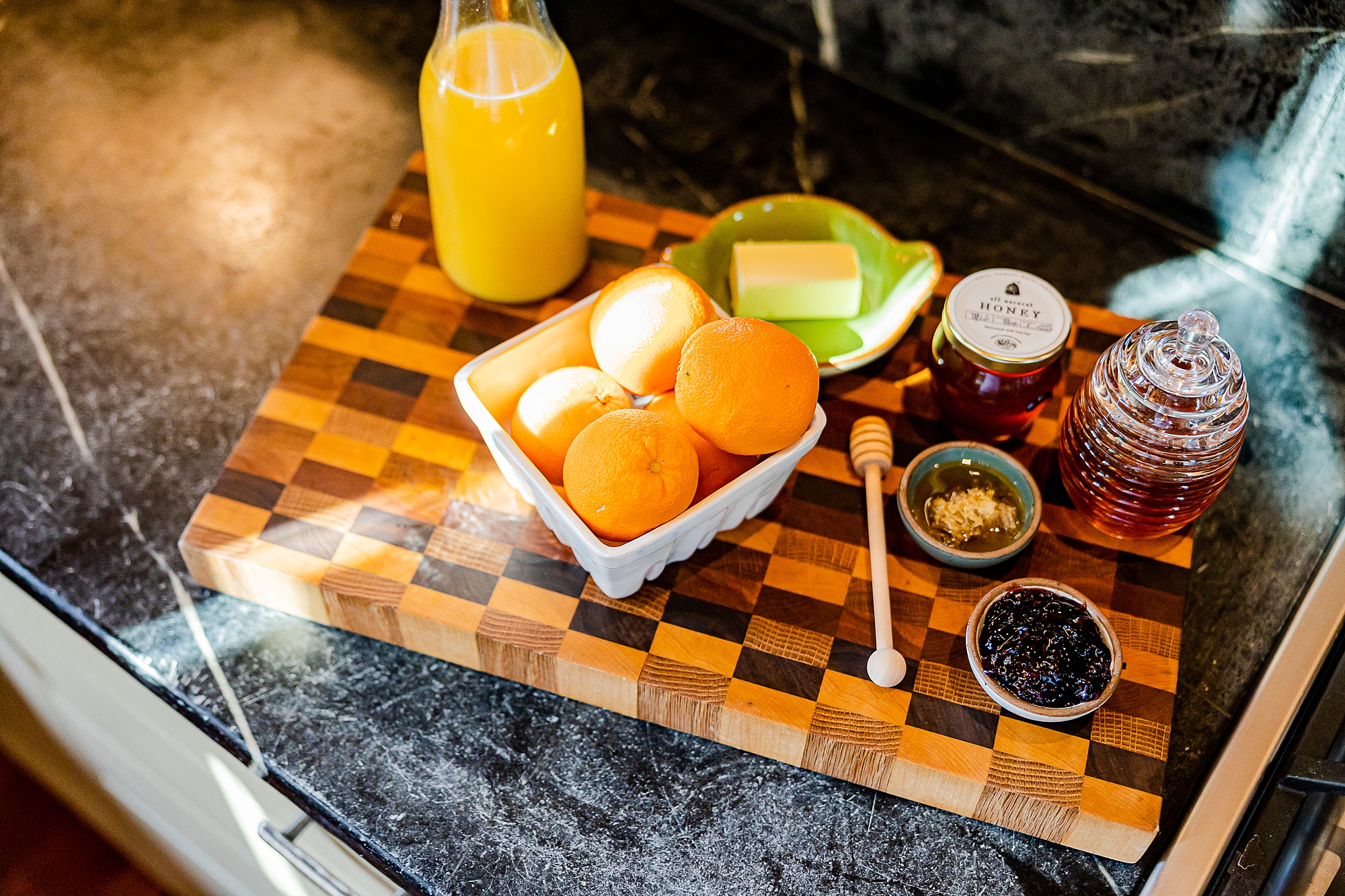 fruit, juice, and butter sit on wooden cutting board during North Corner Haven product photos