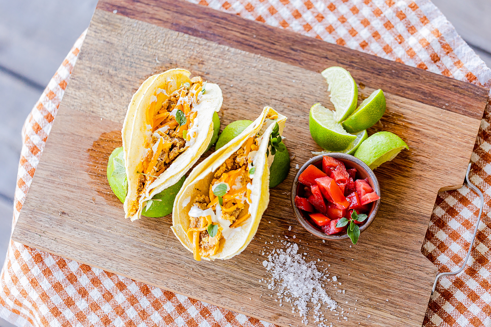 tacos with tomato and lime on cutting board 