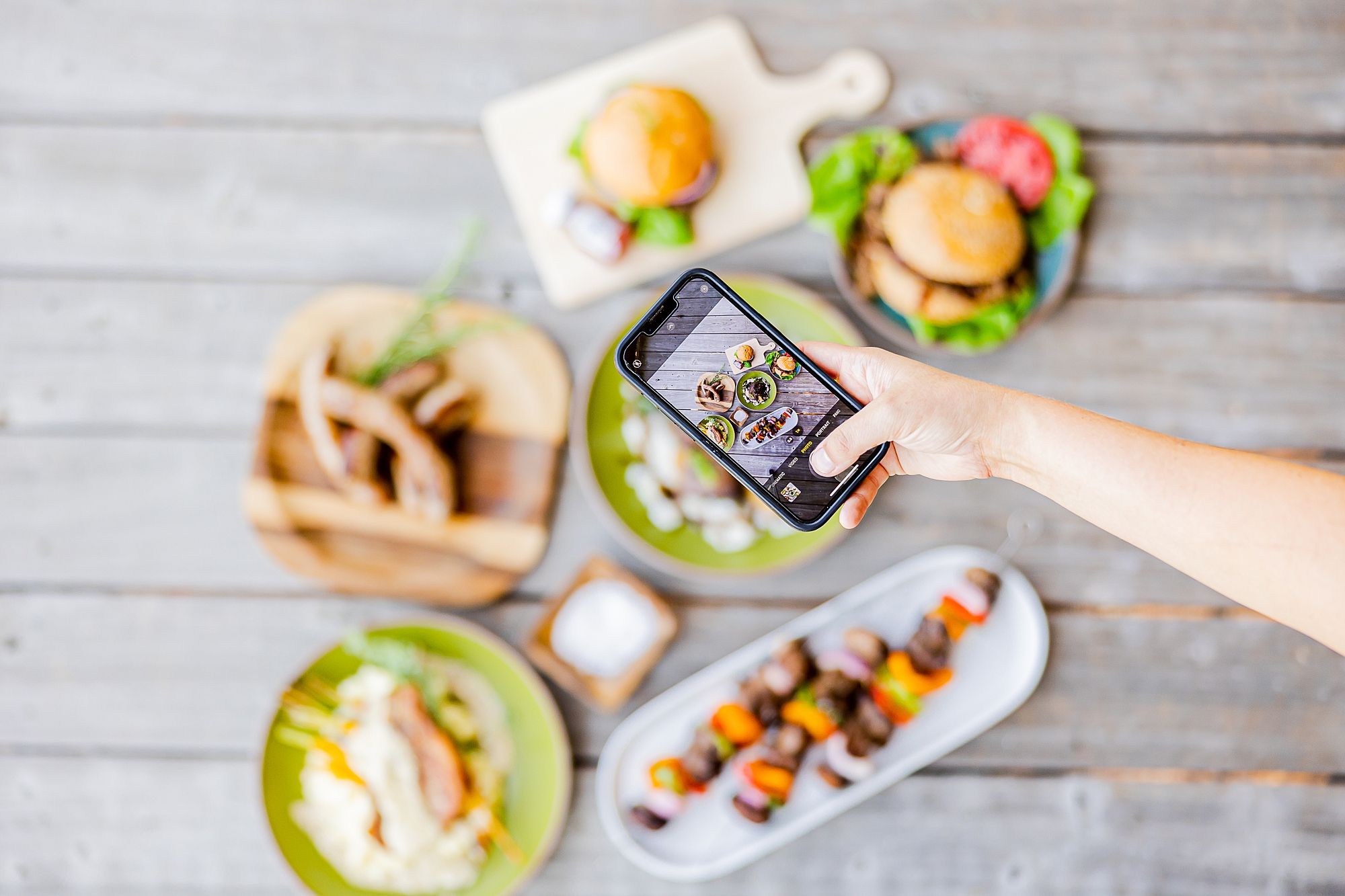 woman holds iPhone above food during North Corner Haven product photos