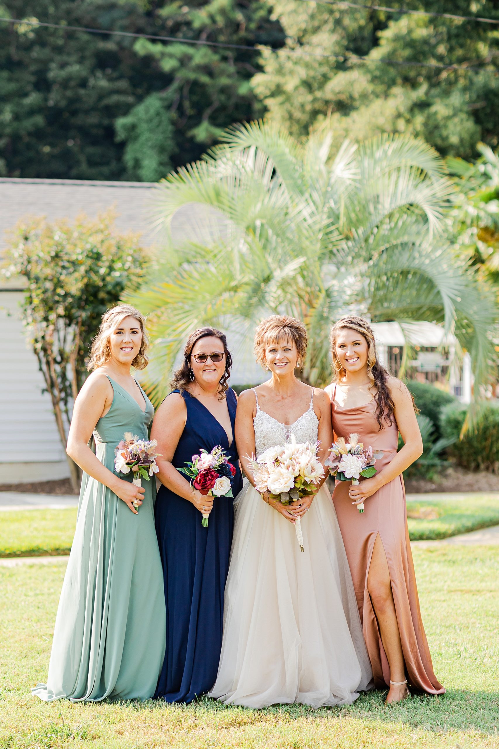 bride poses with daughters and sister as bridesmaids 