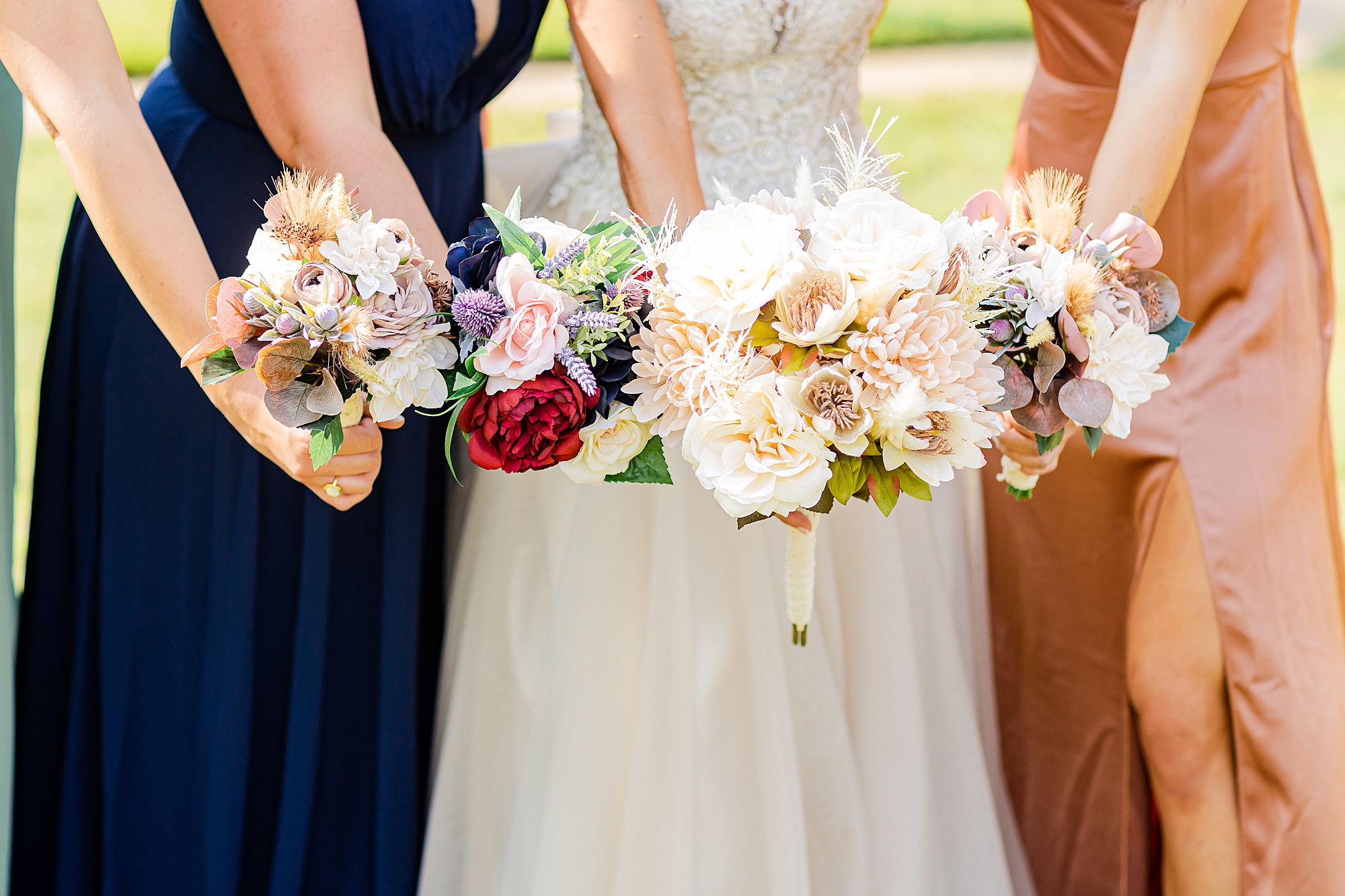 bride and bridesmaids hold bouquets out for NC wedding day 