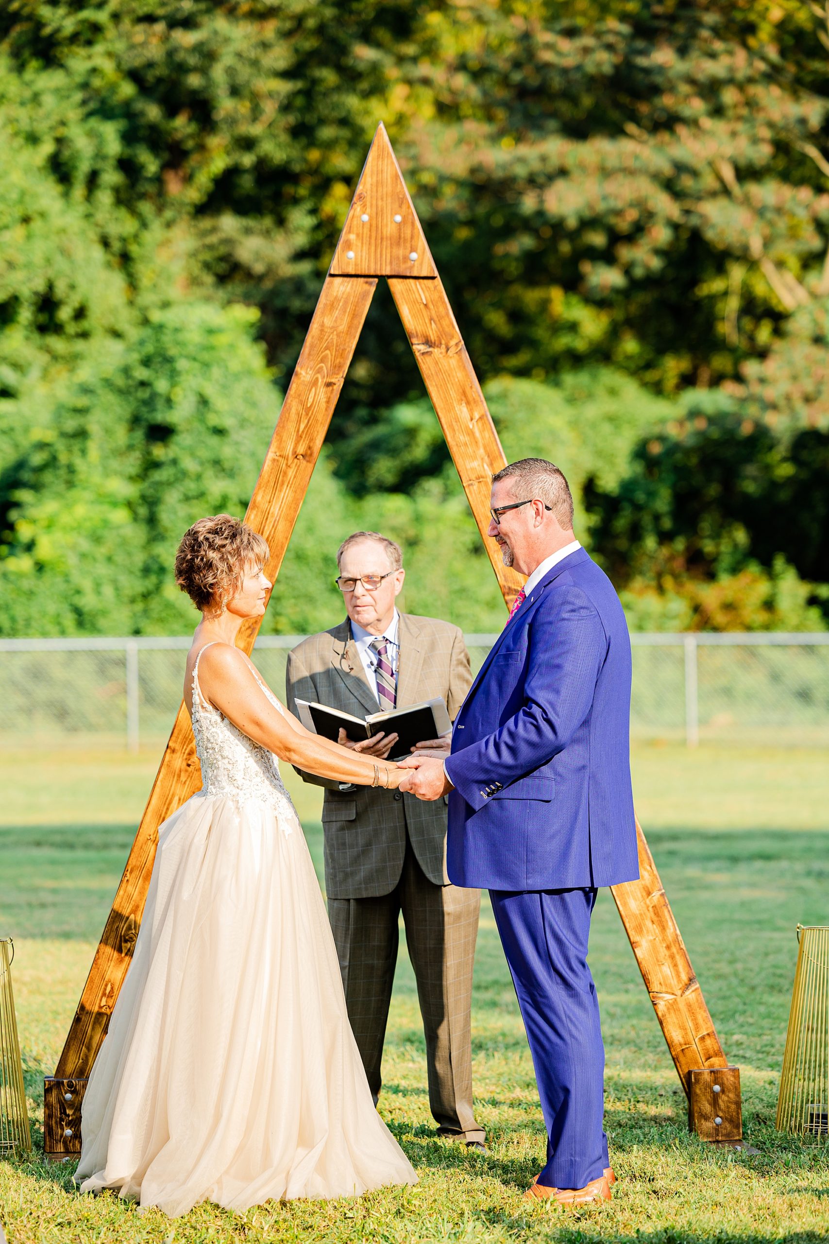 bride and groom exchange vows by wooden alter at Starclaire Recreation Club
