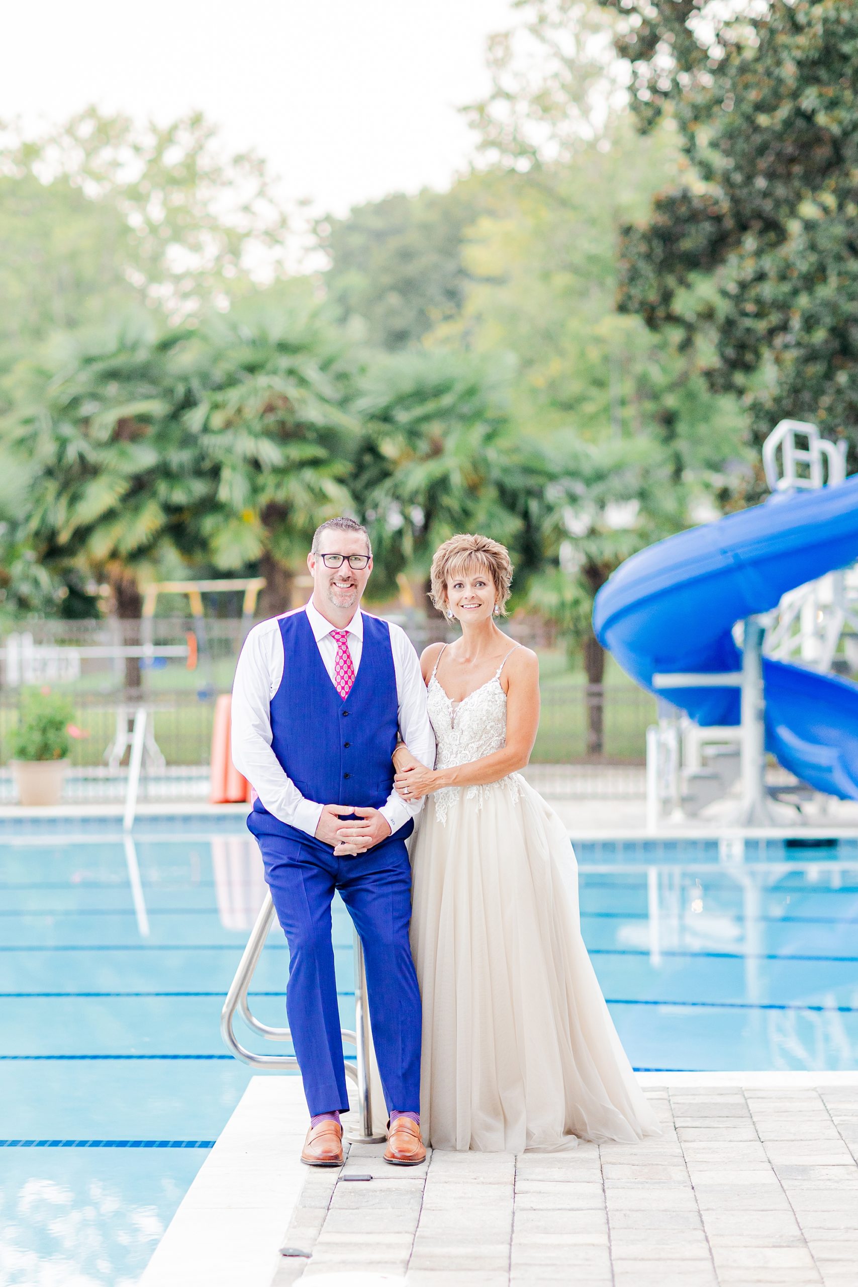 bride and groom hold hands by pool at Starclaire Recreation Club