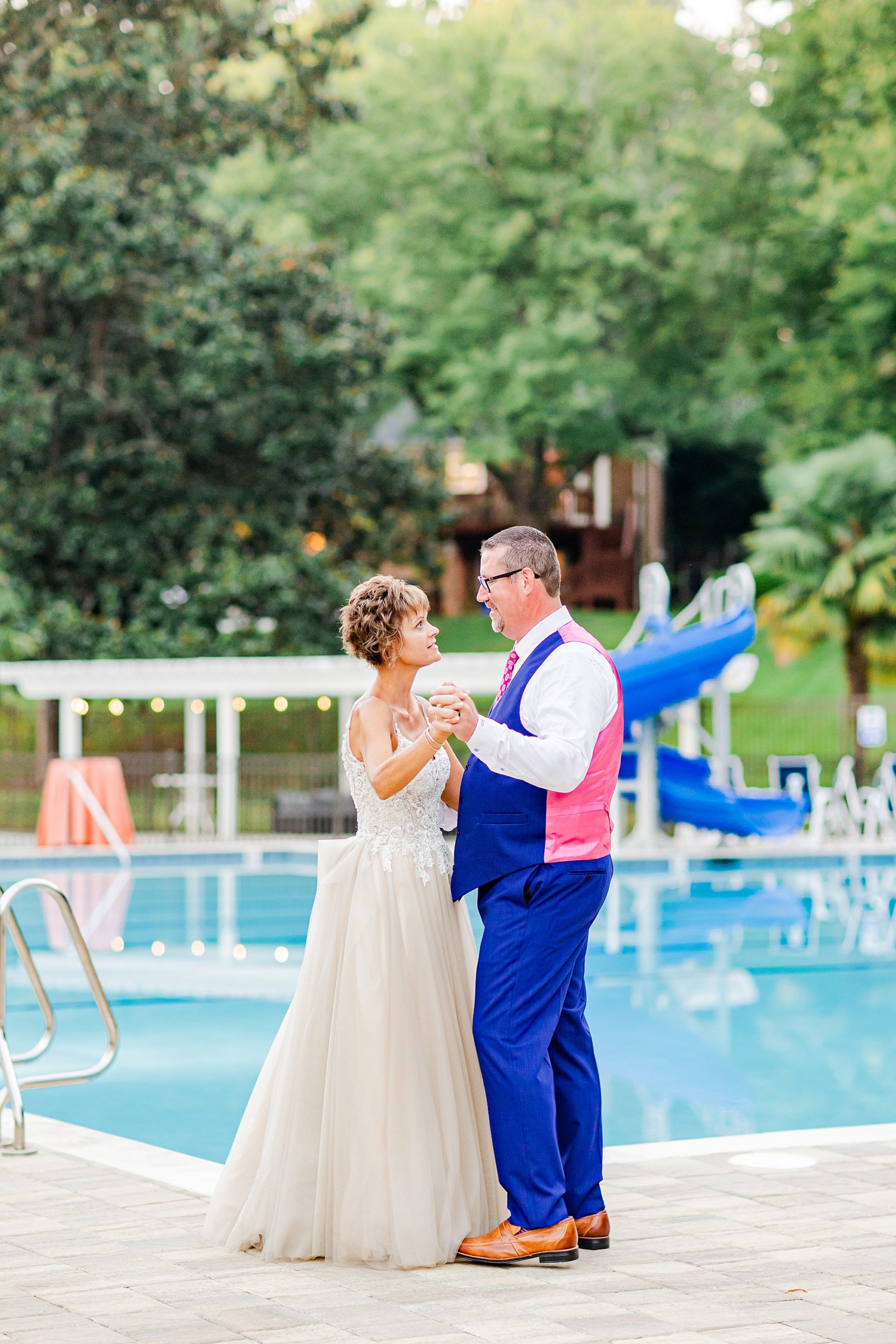 newlyweds dance on the edge of pool at Starclaire Recreation Club