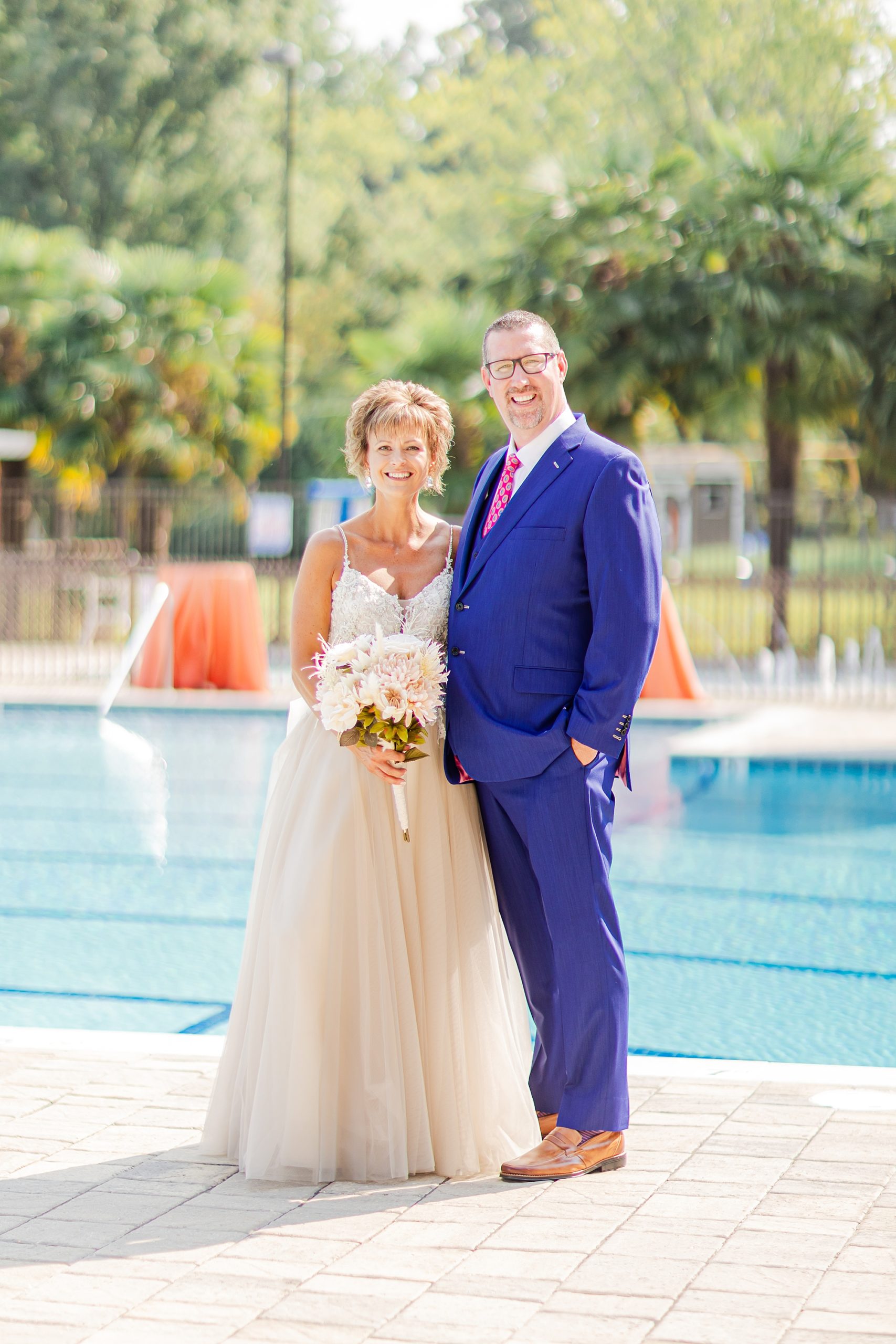 newlyweds pose by pool at Starclaire Recreation Club 