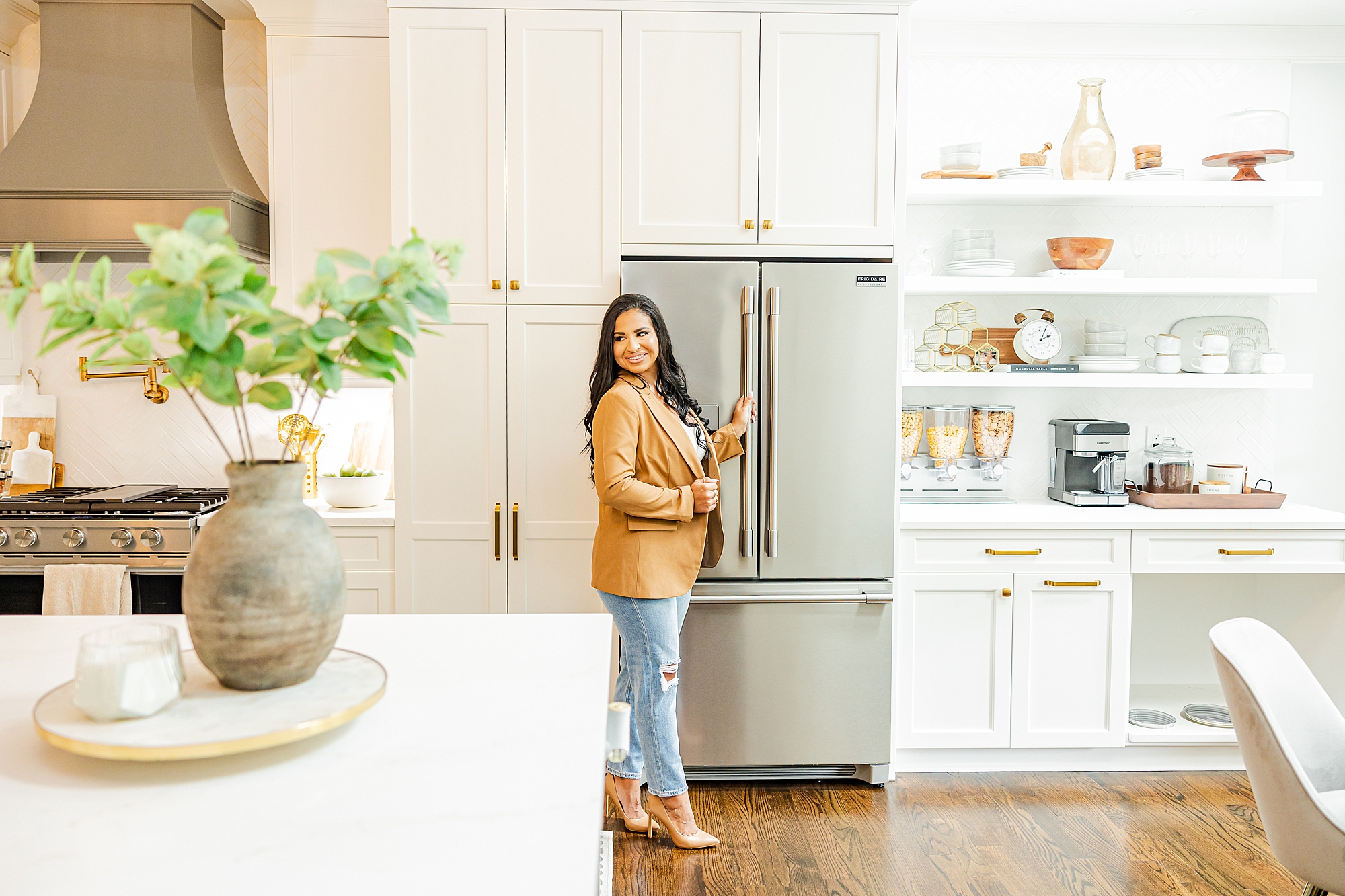 designer stands by new fridge in custom kitchen 