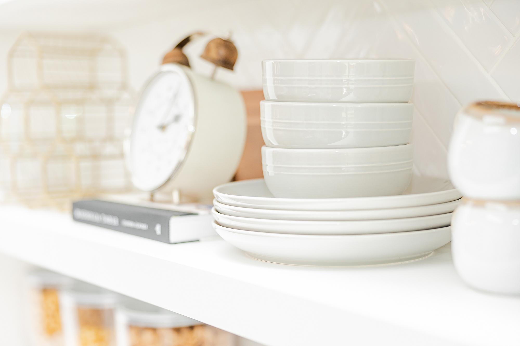 stack of white plates and clock in kitchen 