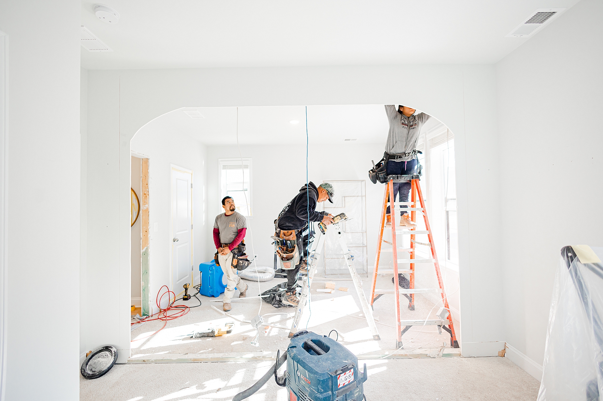 contractors work on molding between rooms 