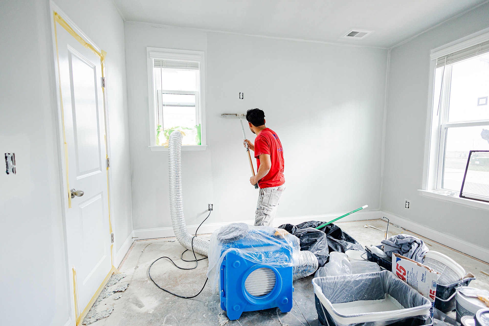 contractor paints walls during renovations with Turn Key Solutions for home photography studio 
