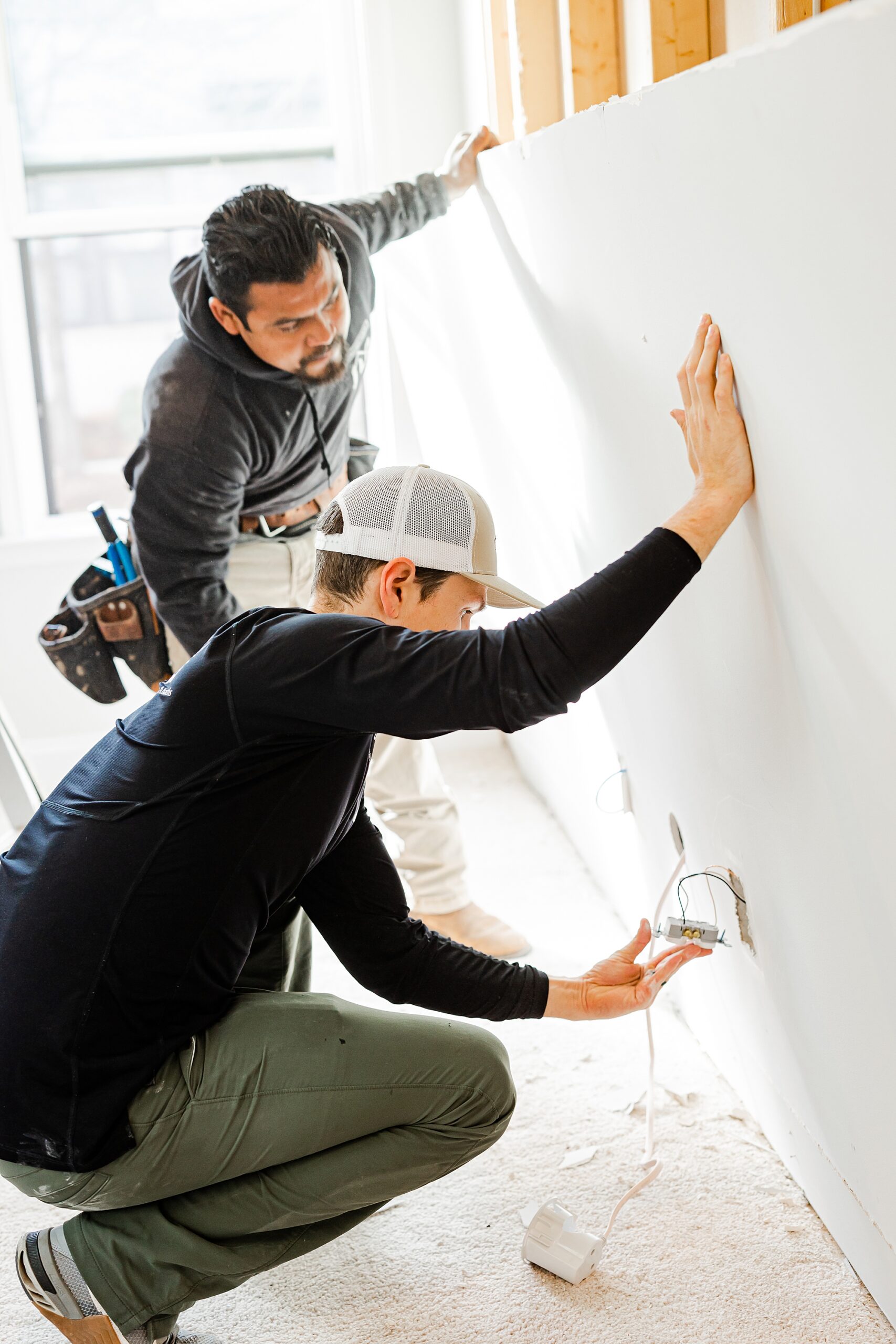 men hold up drywall during renovations with Turn Key Solutions