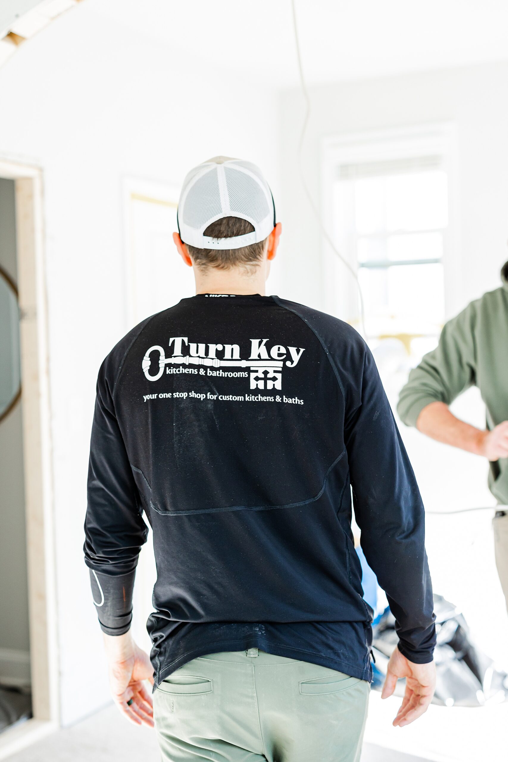 contractor in black Turn Key Solutions shirt talks with worker